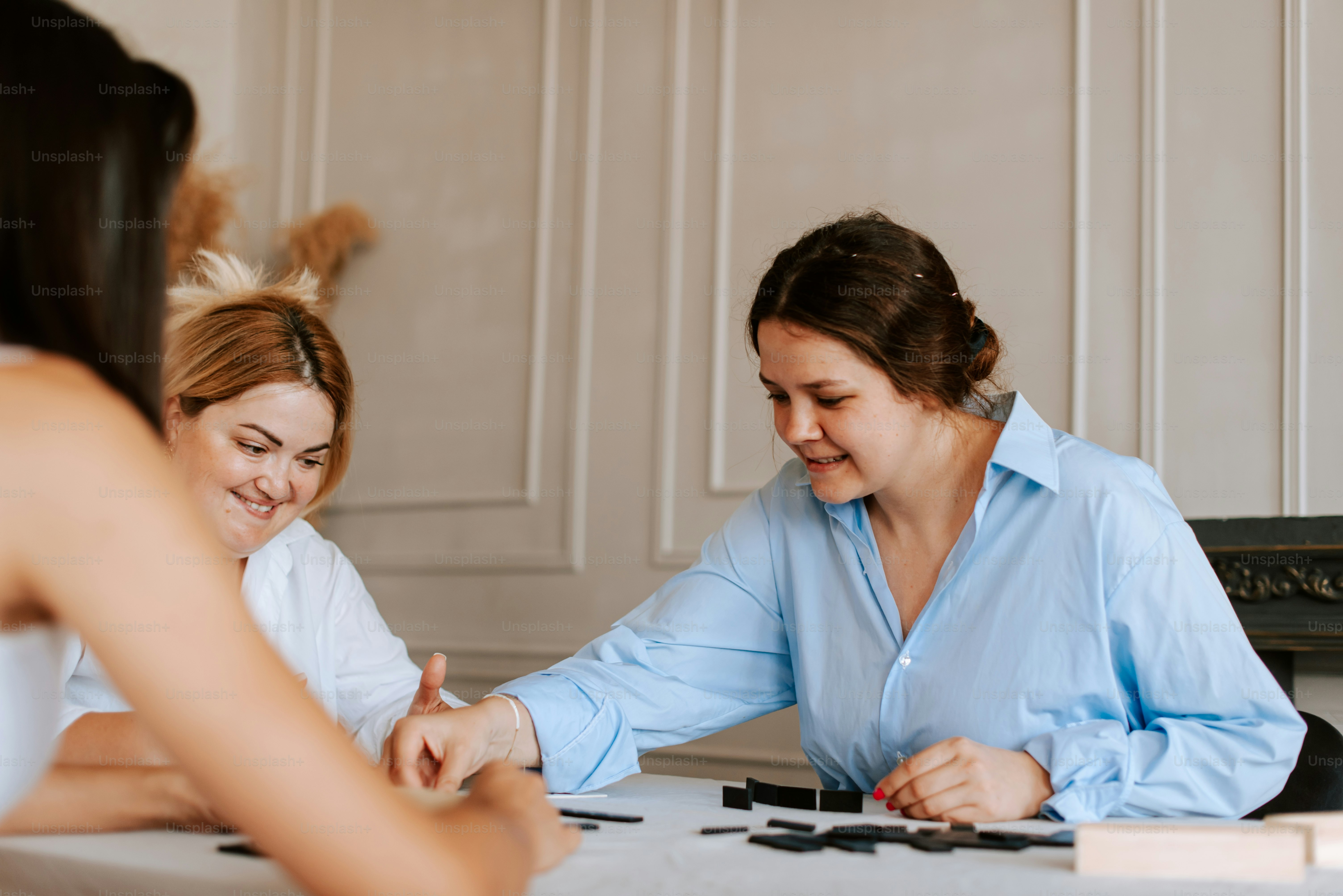 Two women sitting at a table playing a game