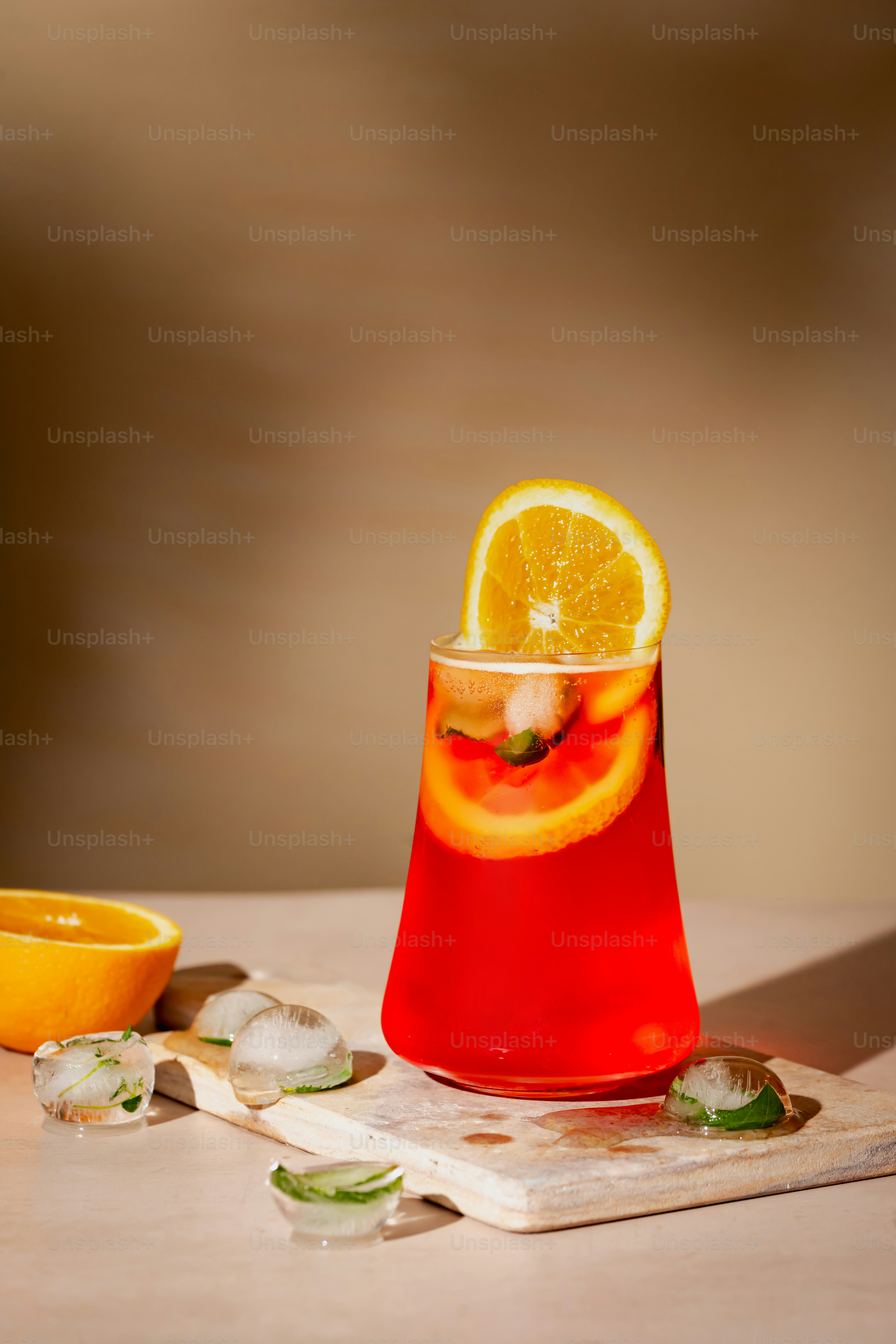 Minuman merah dengan sepotong jeruk di sampingnya