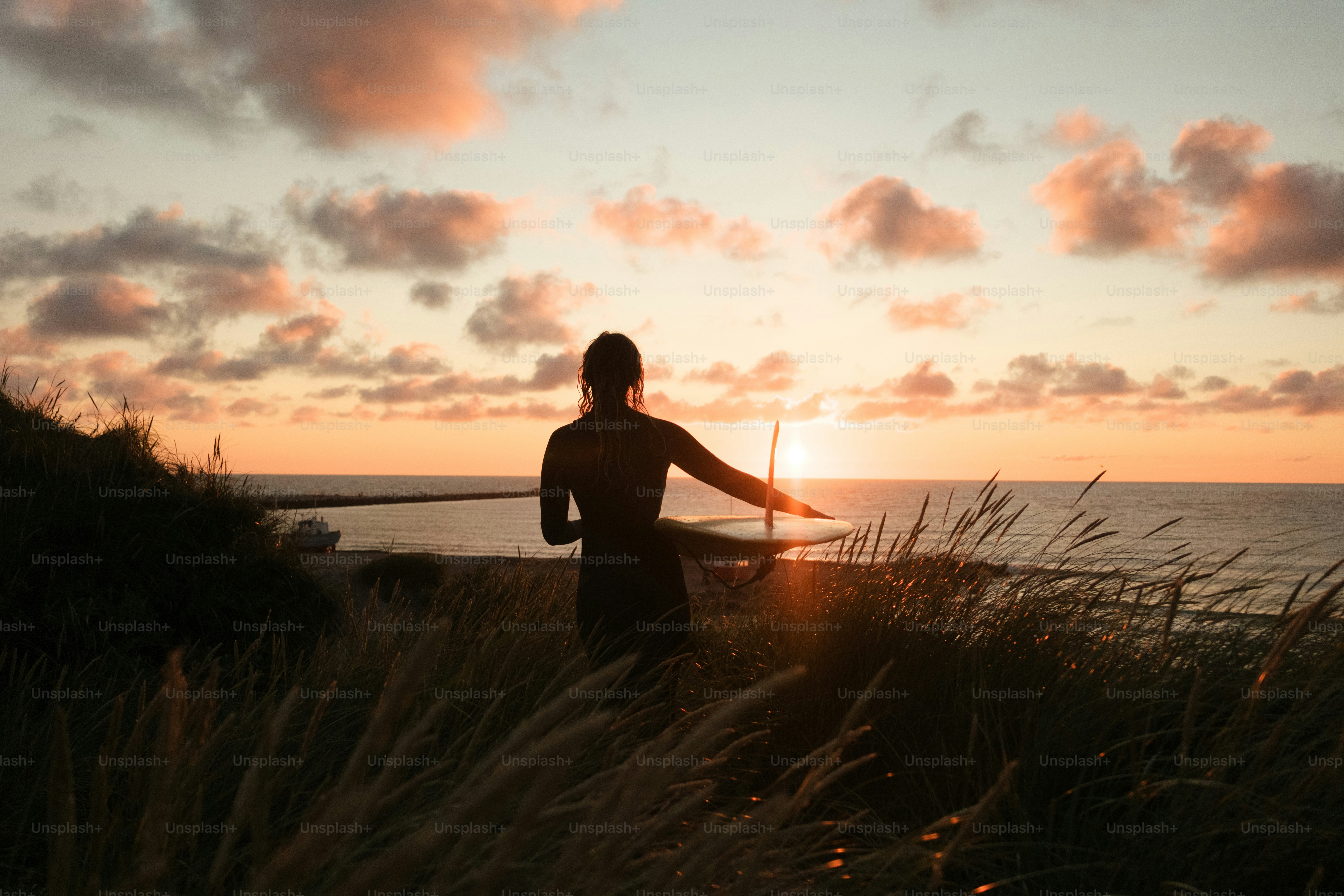 A man standing on top of a grass covered hillside