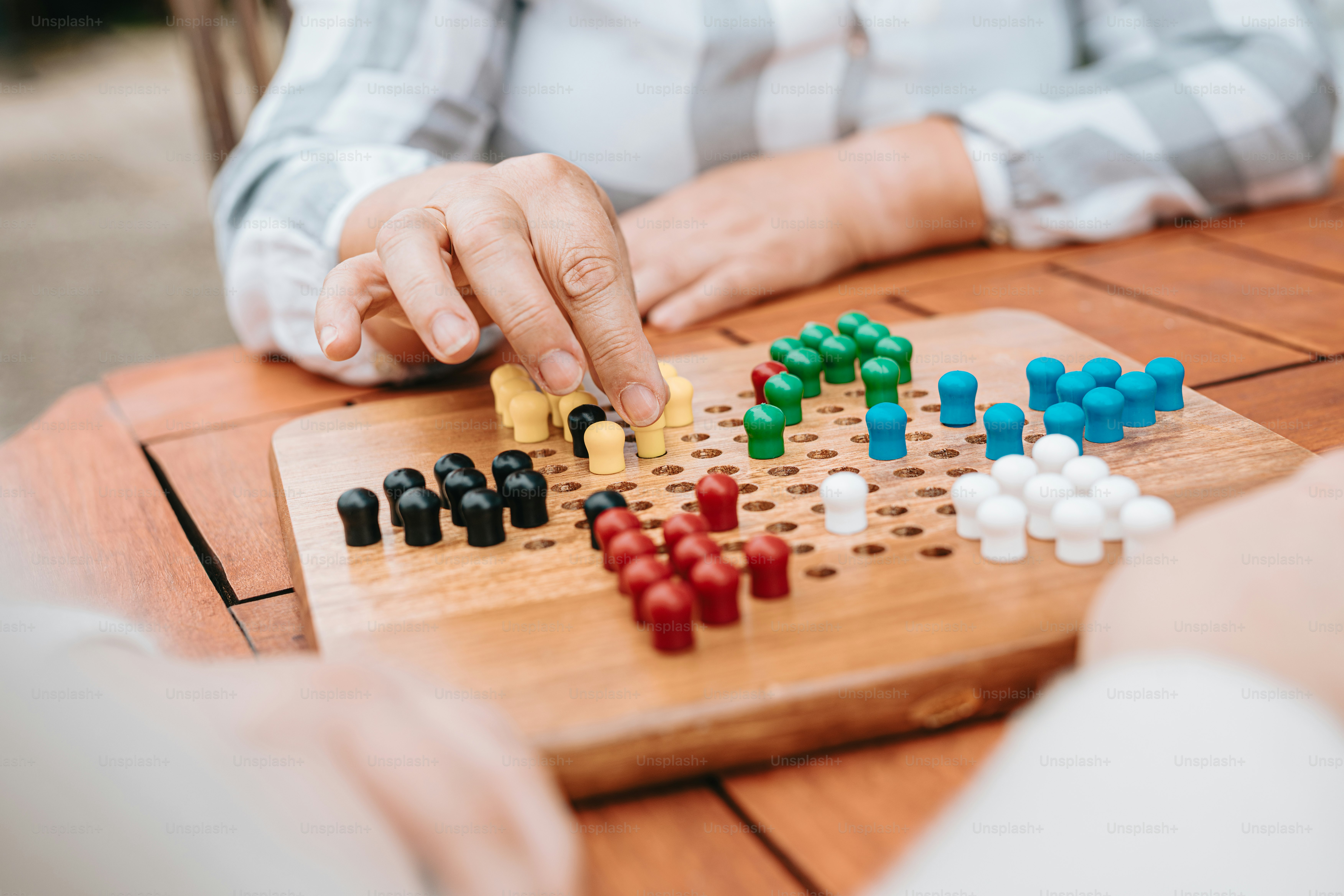 Eine Frau, die auf einem Holztisch eine Partie Dame spielt