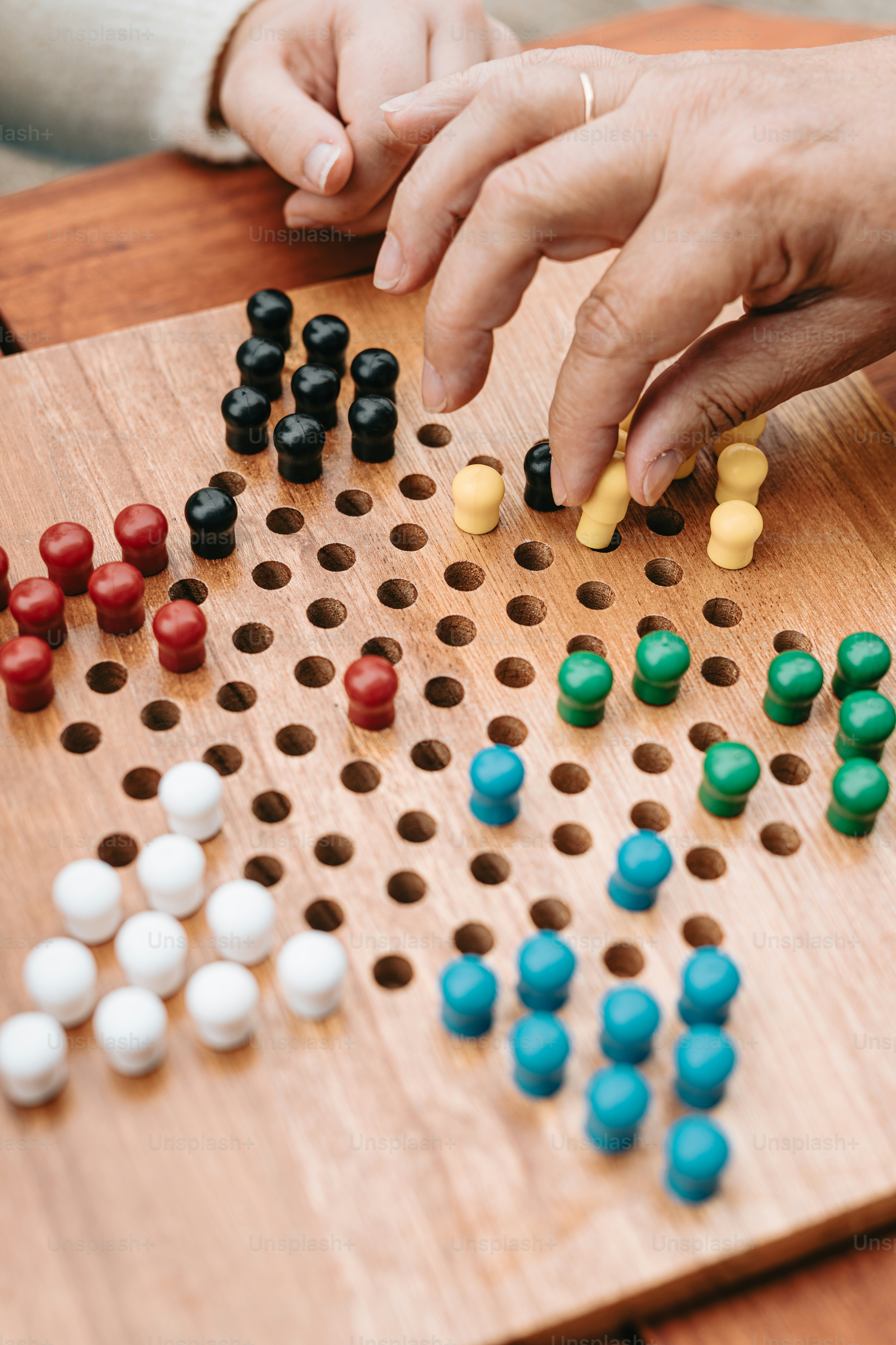 Eine Person, die auf einem Holztisch ein Brettspiel spielt