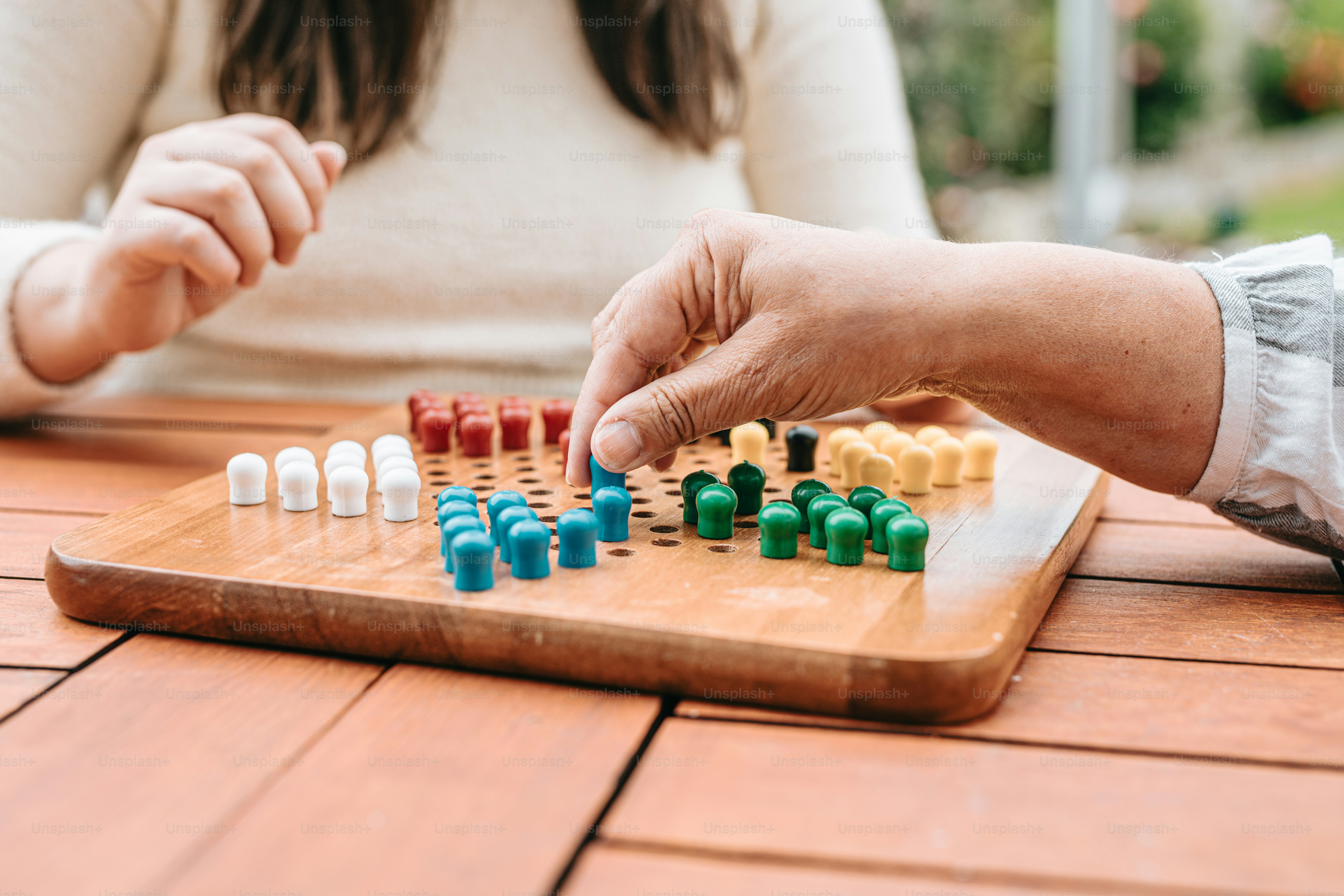 Zwei Personen, die an einem Tisch eine Partie Dame spielen