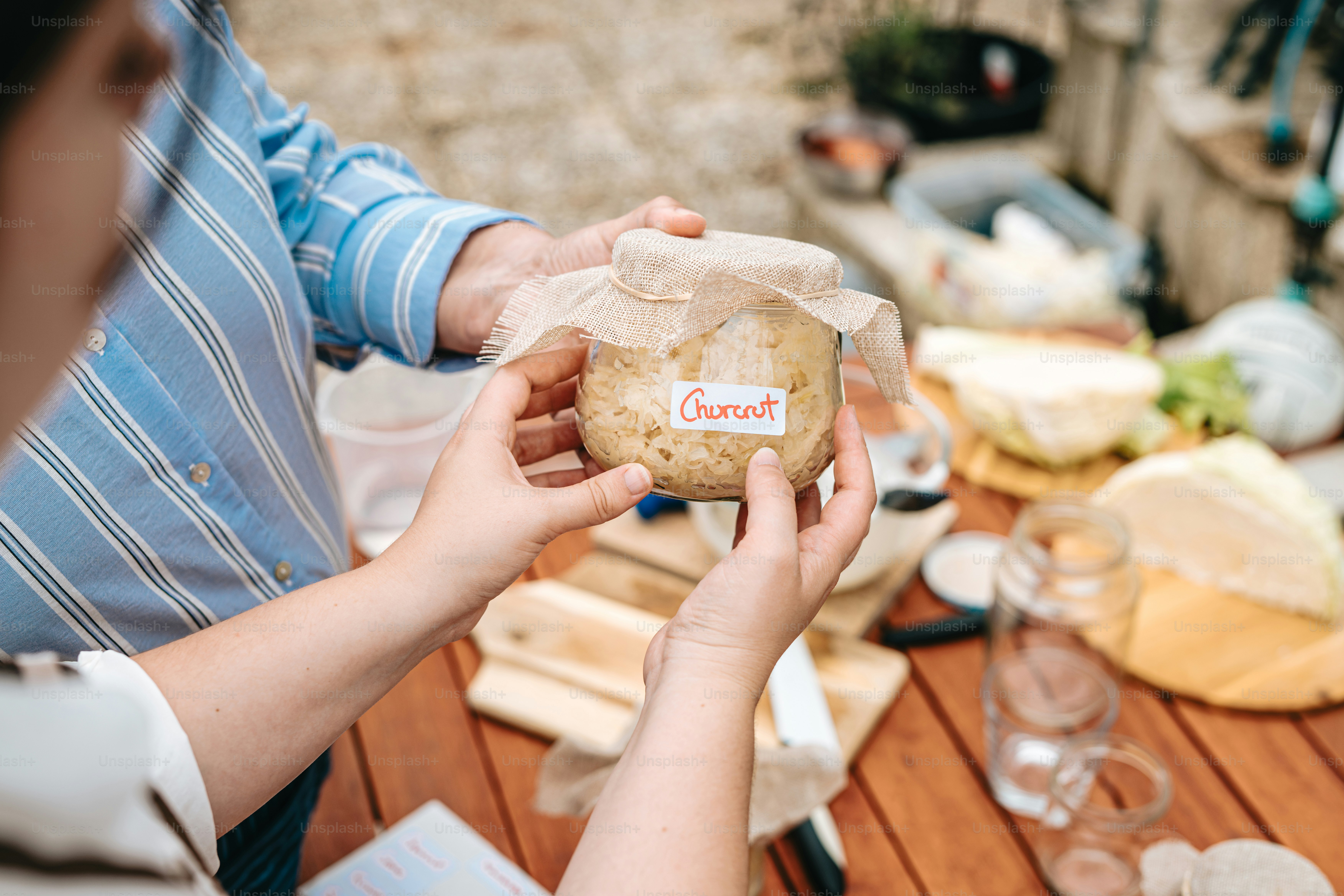 A woman holding a loaf of bread on top of a wooden table