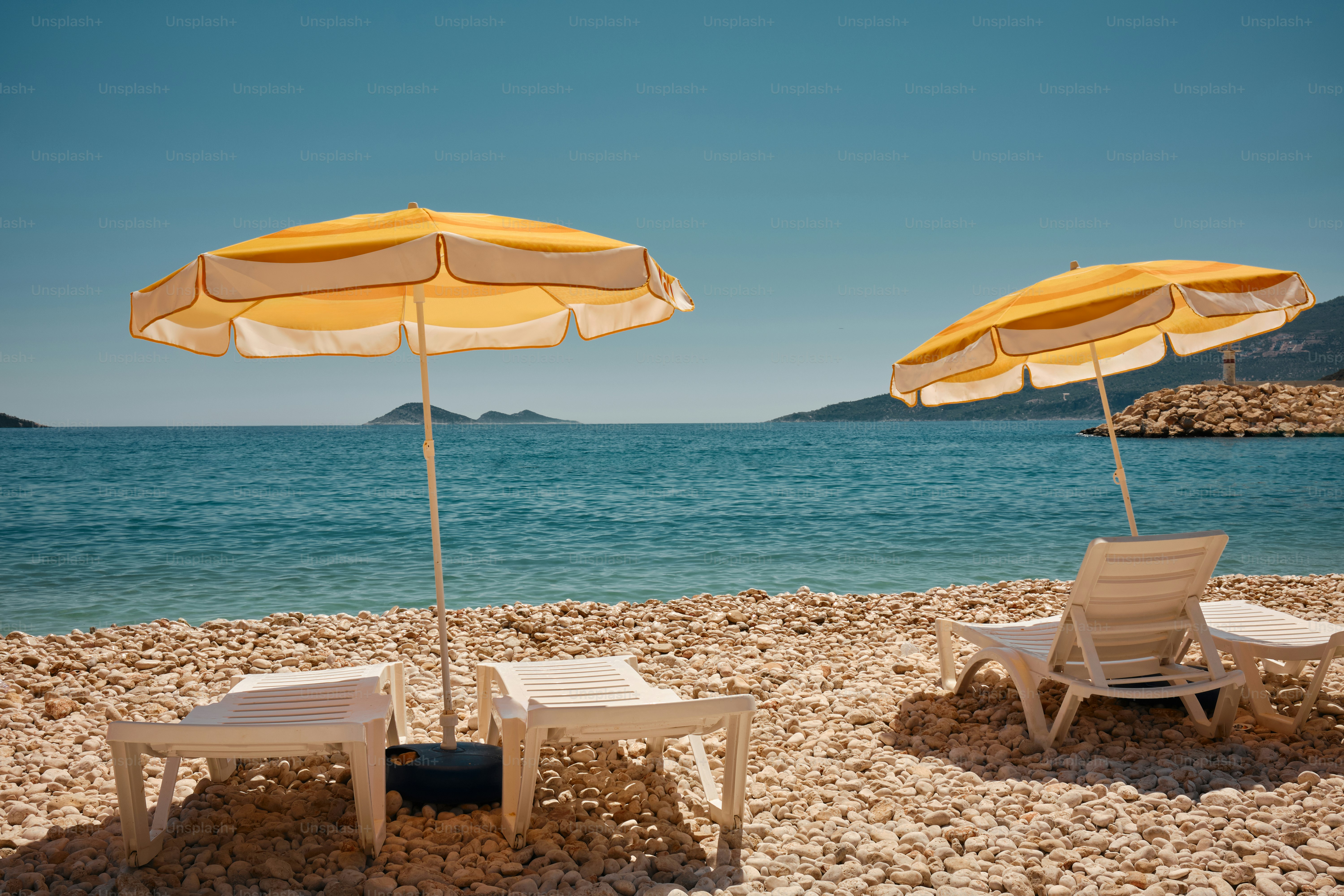 Two chairs and two umbrellas on a beach