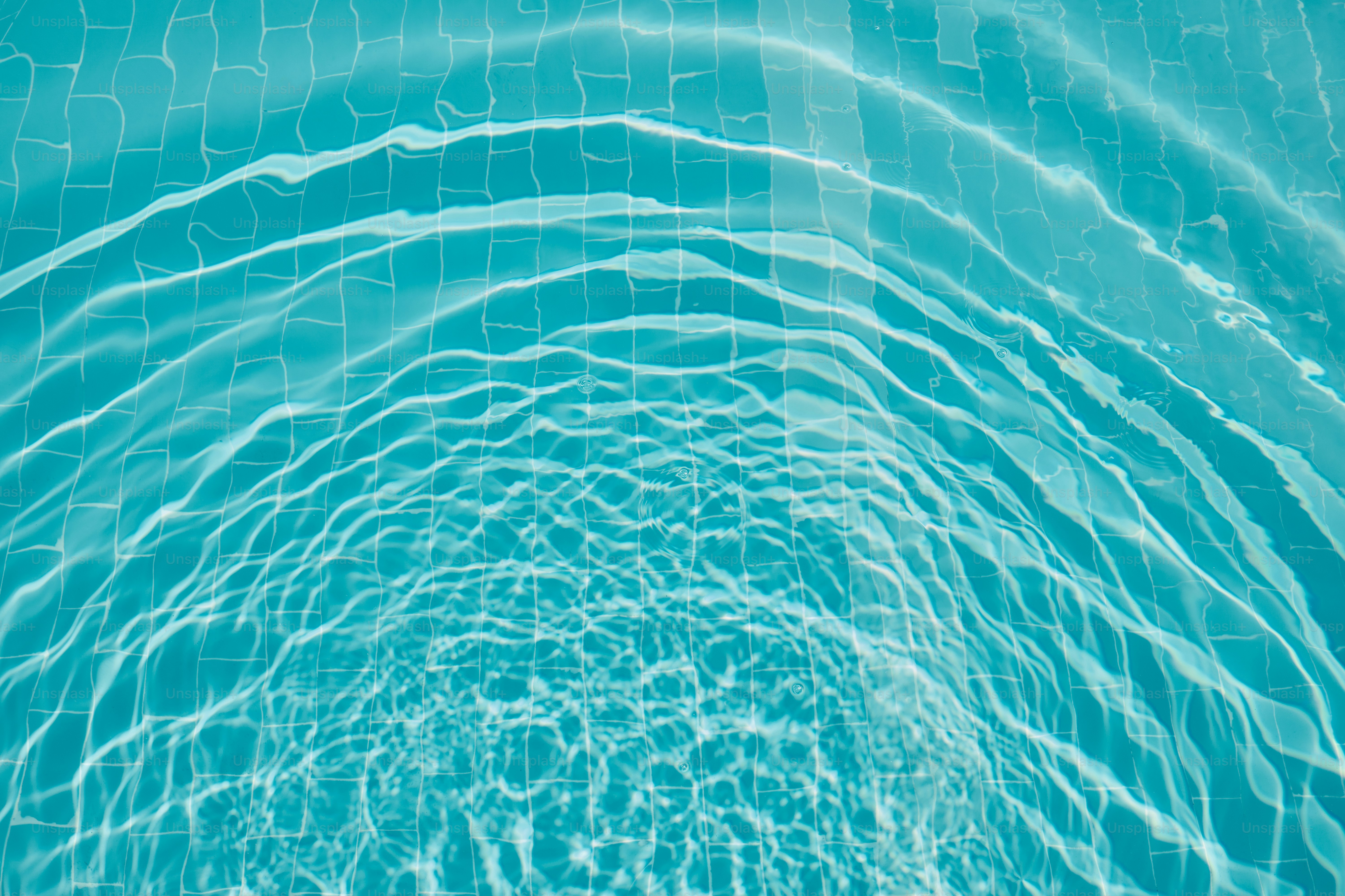 A swimming pool with blue water and ripples photo – Wallpaper Image on ...