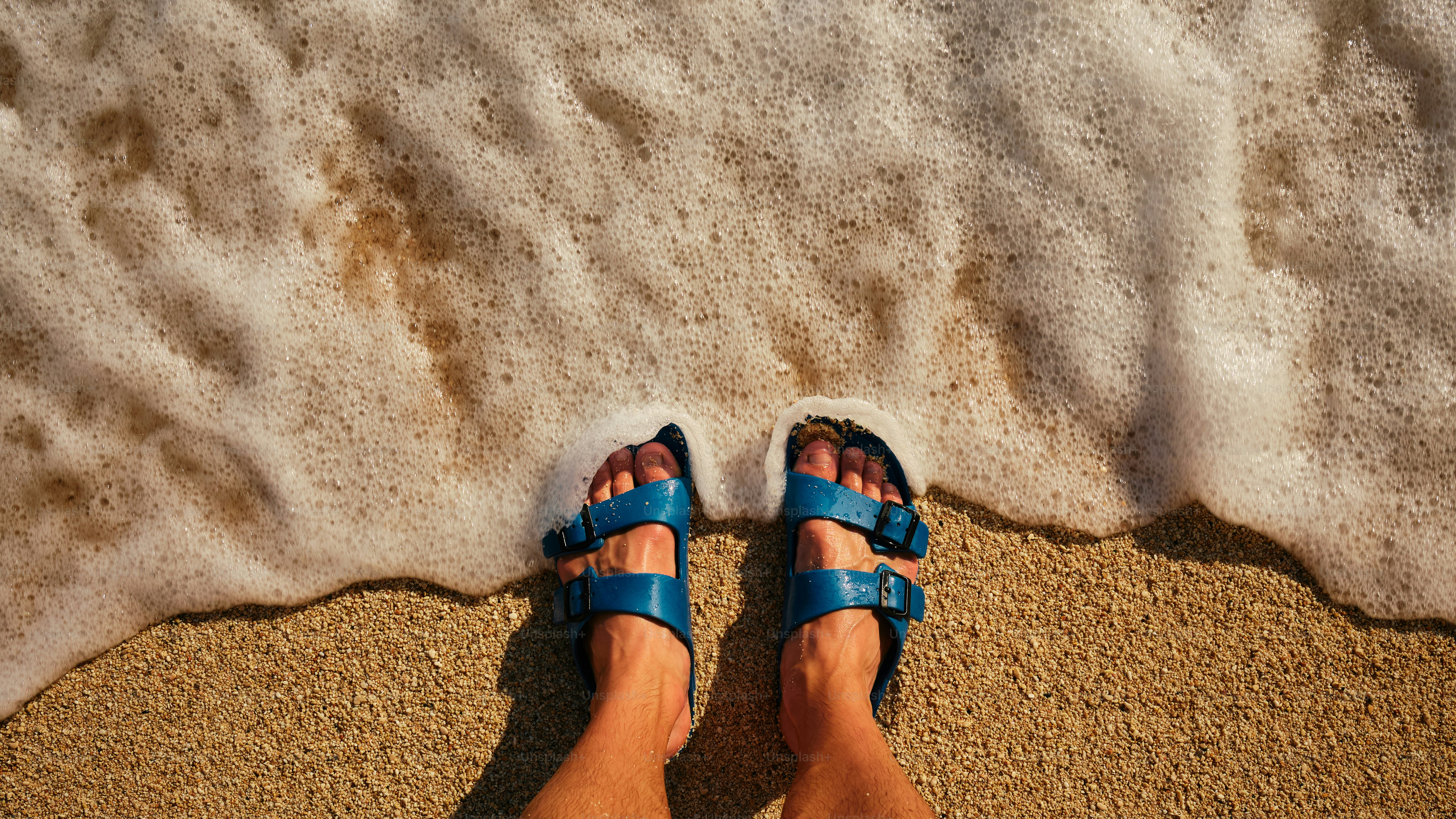 legs with sandals on the beach