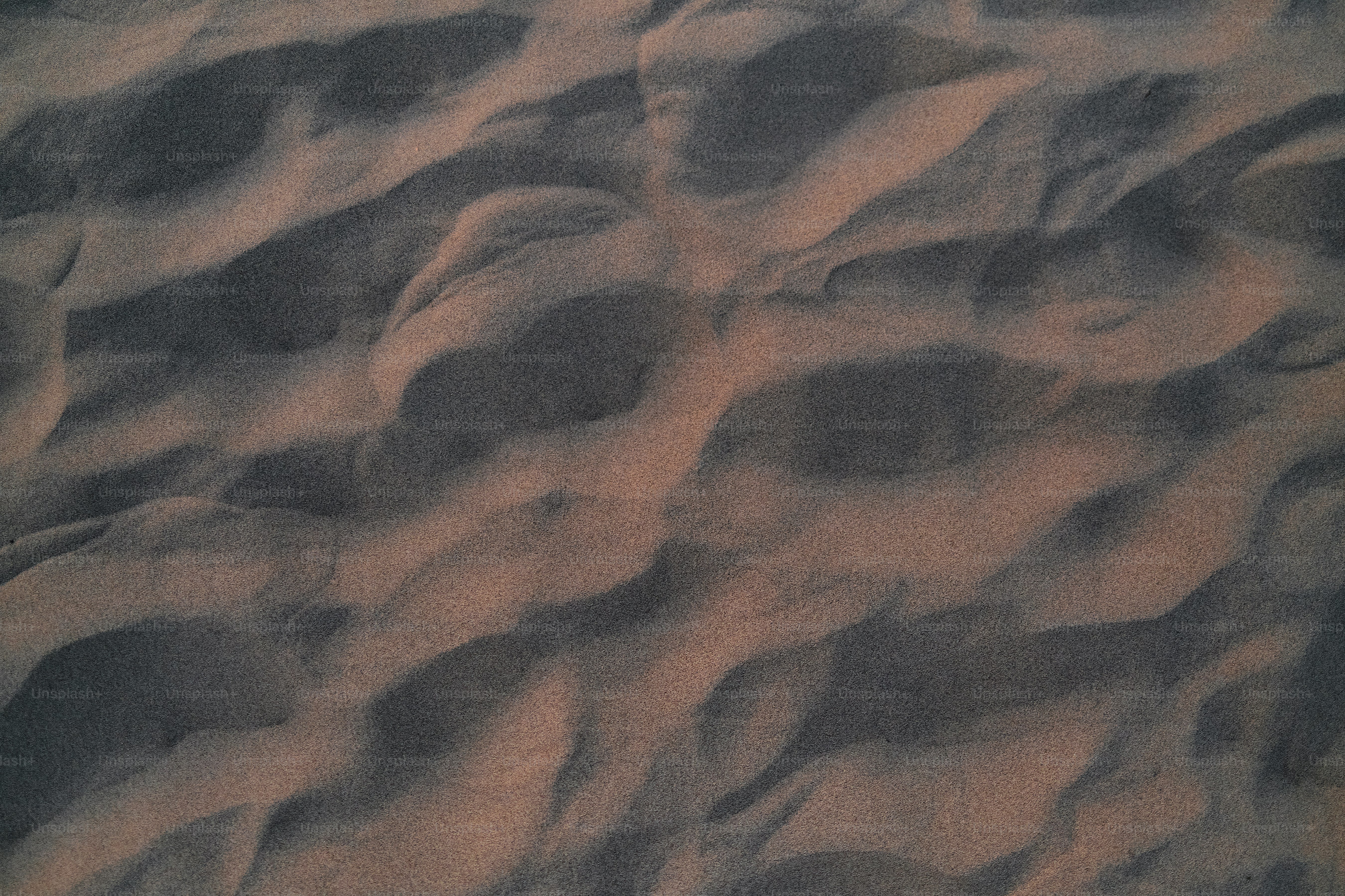 A close up of a sand dune with footprints in the sand