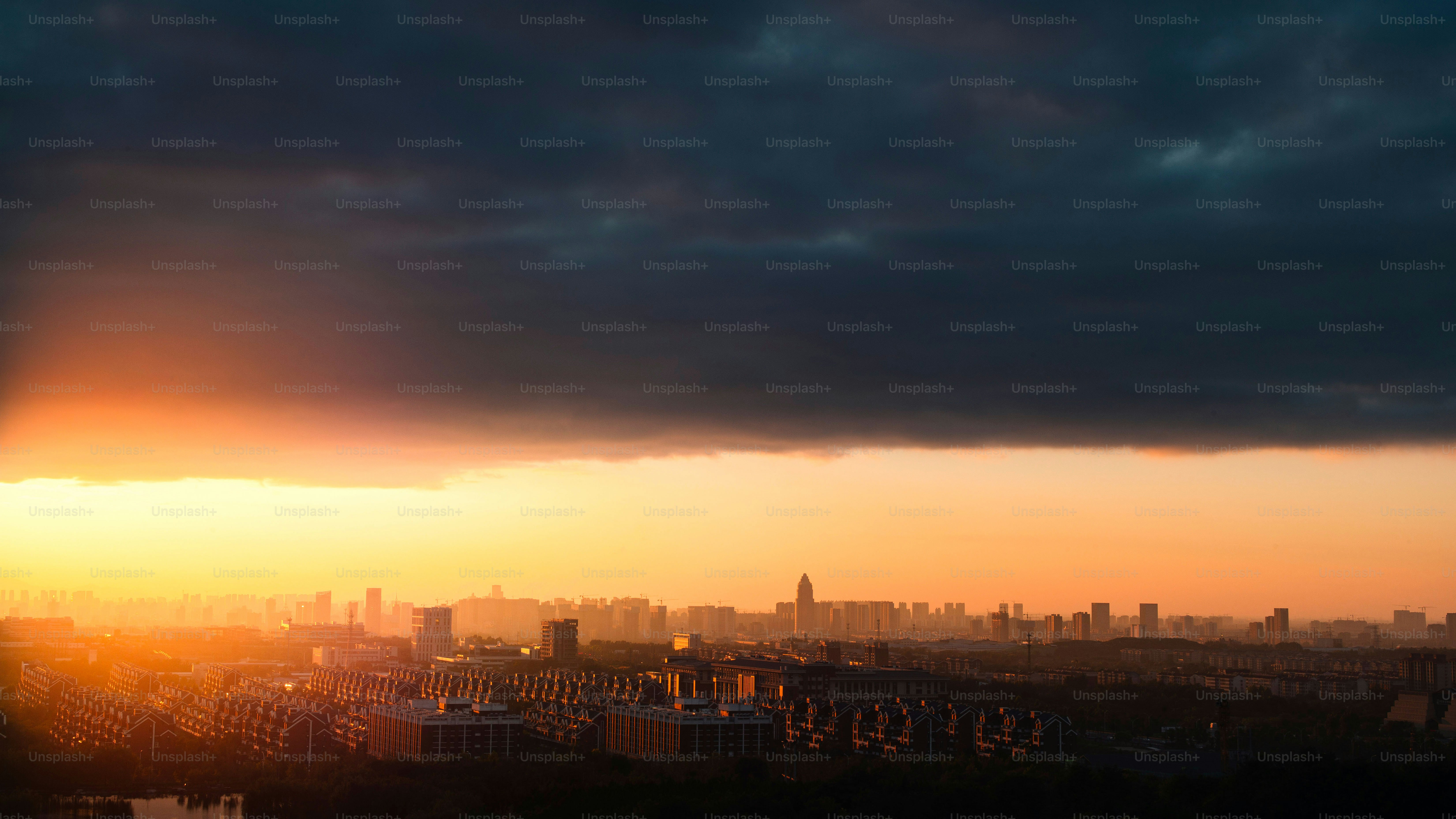 The sun is setting over a city with tall buildings