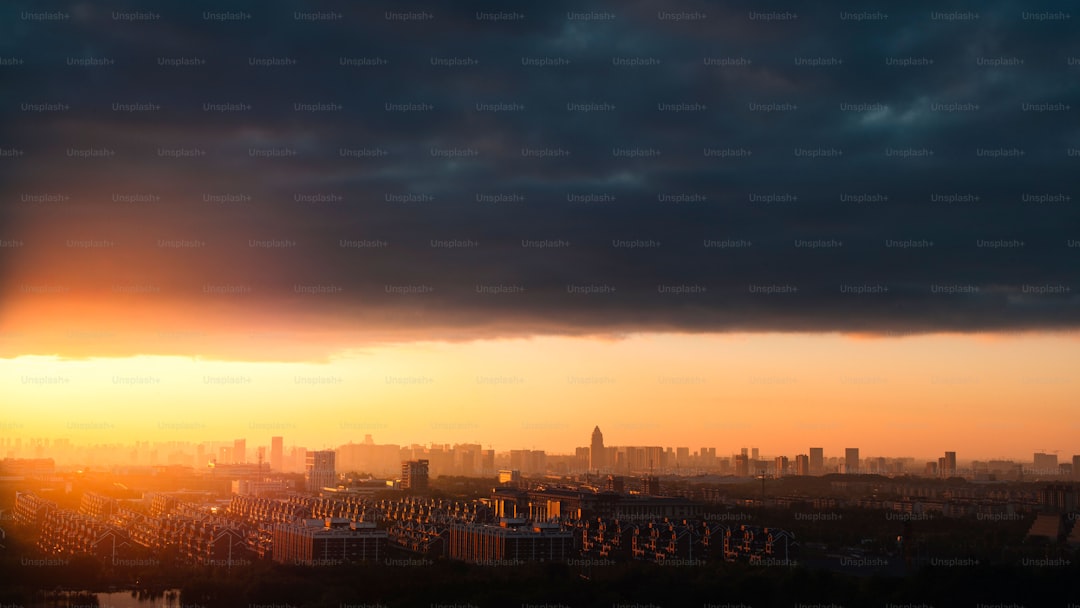 The sun is setting over a city with tall buildings