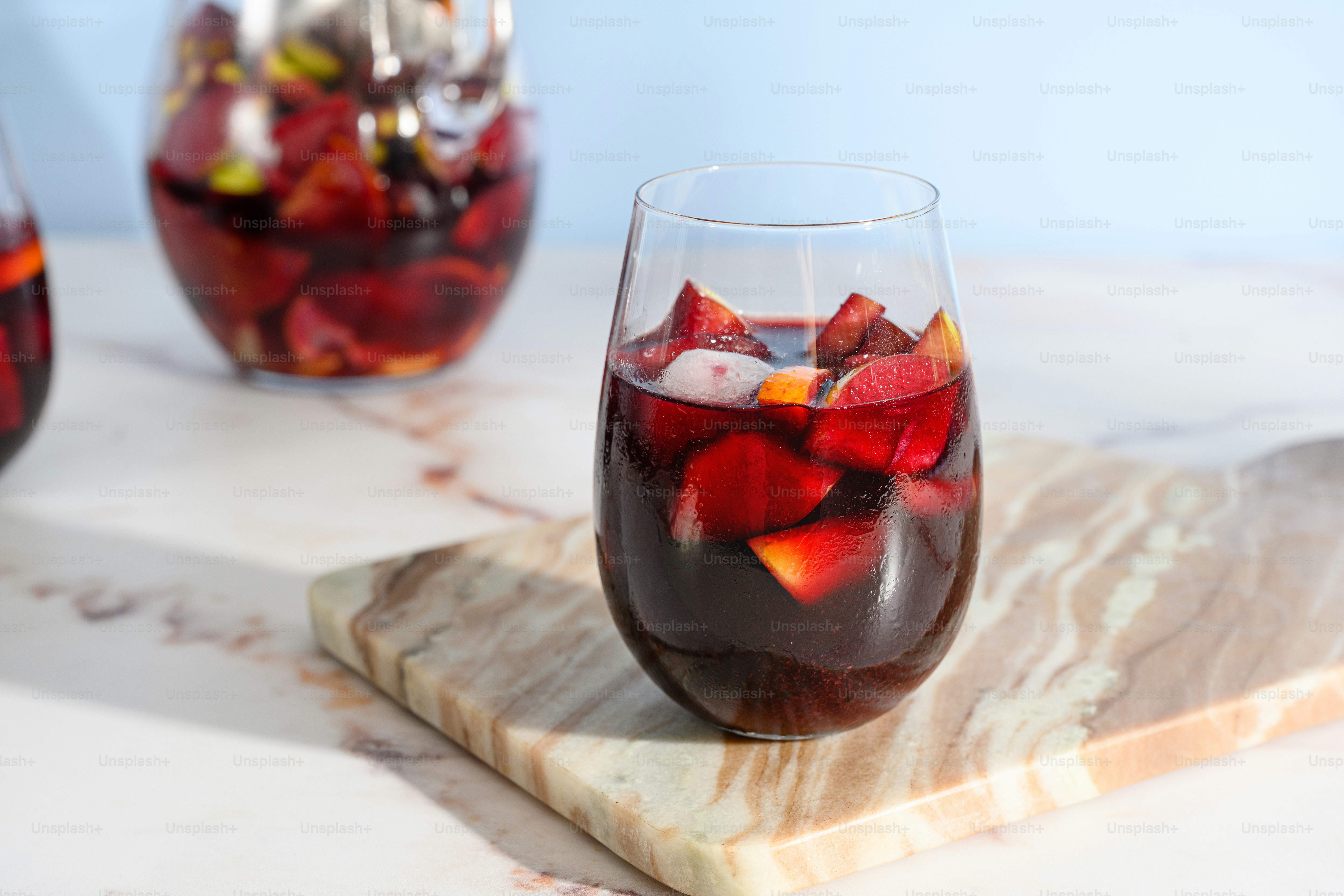 A glass filled with liquid sitting on top of a marble slab