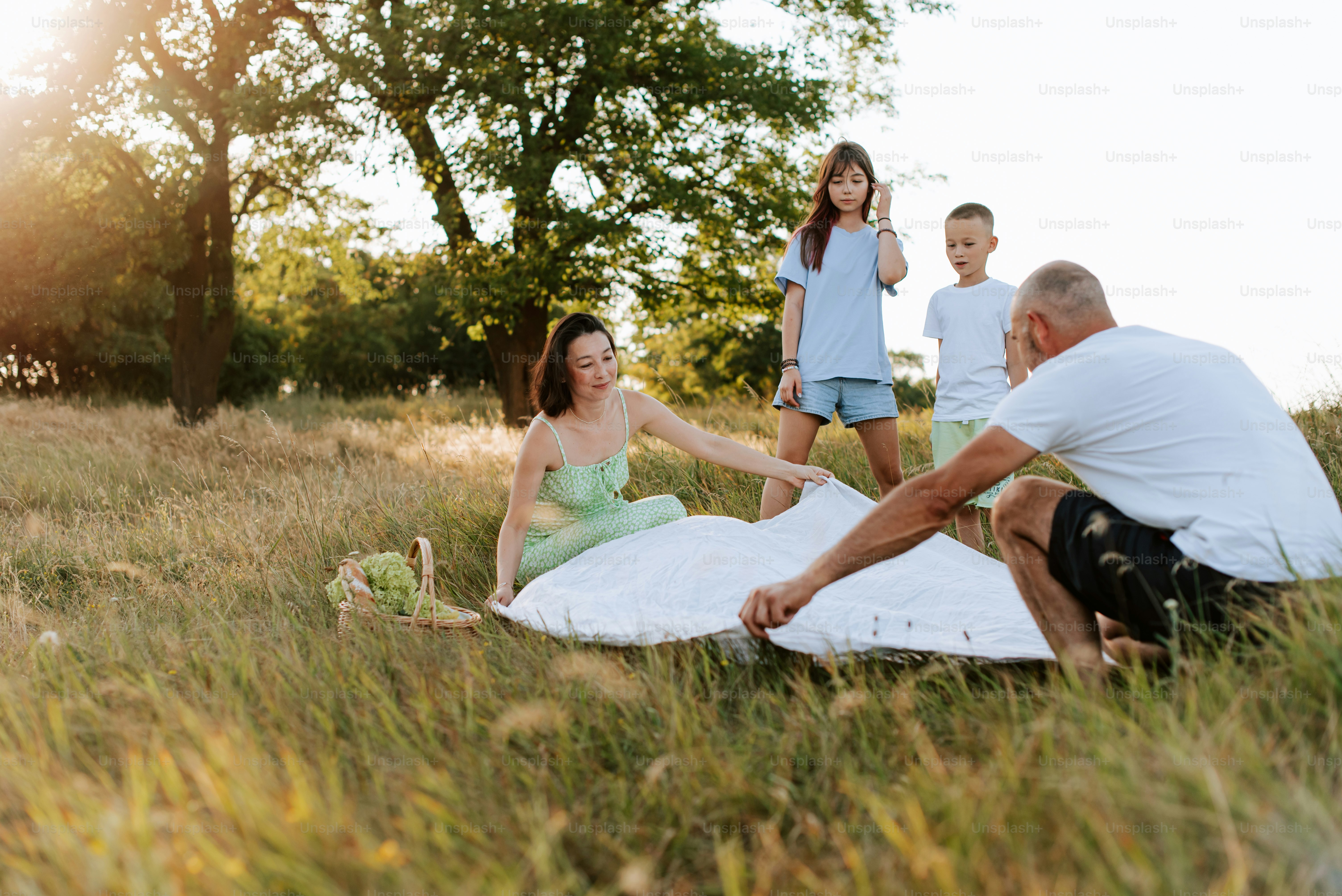 Une famille assise sur une couverture dans un champ