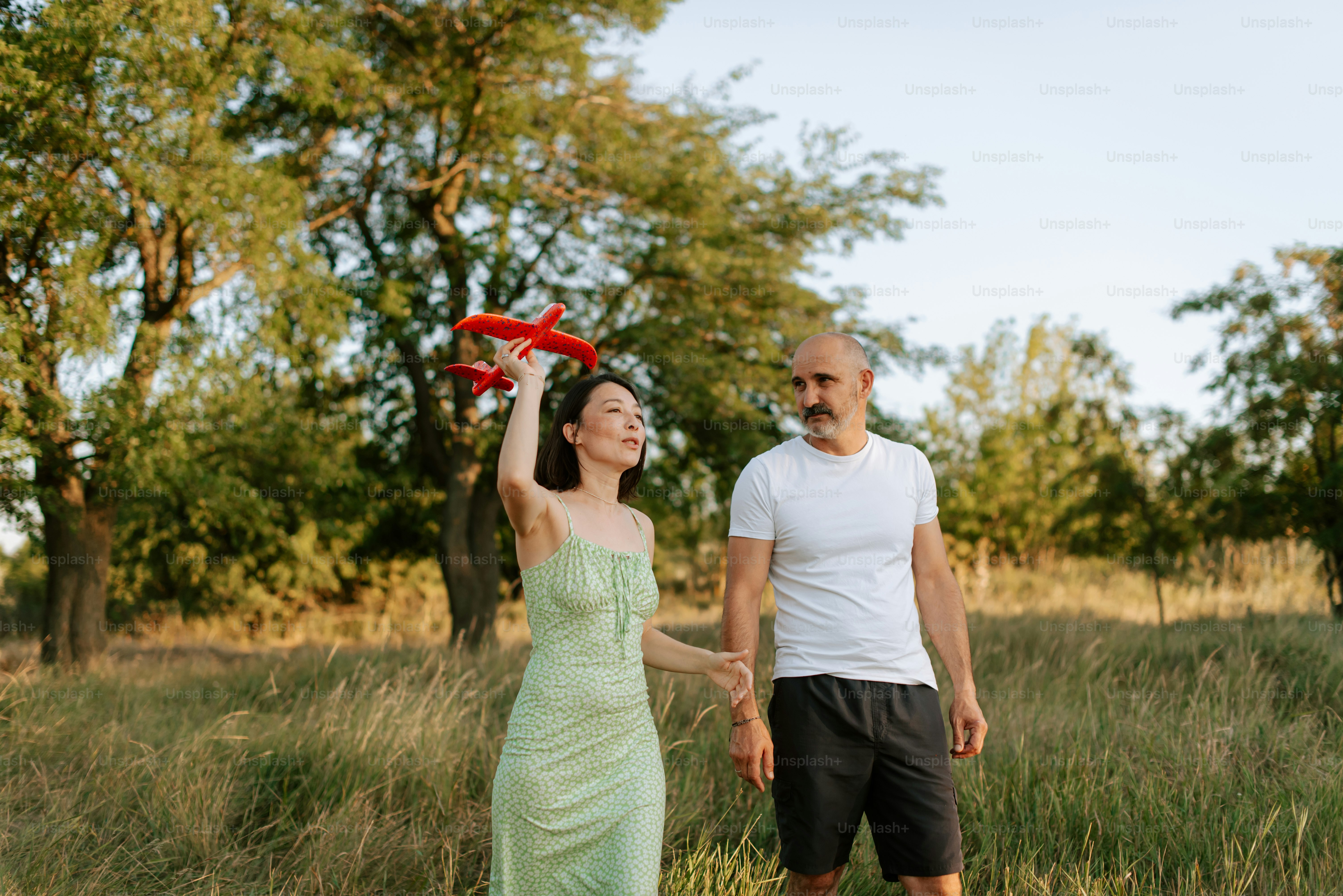 A man and a woman holding a red frisbee