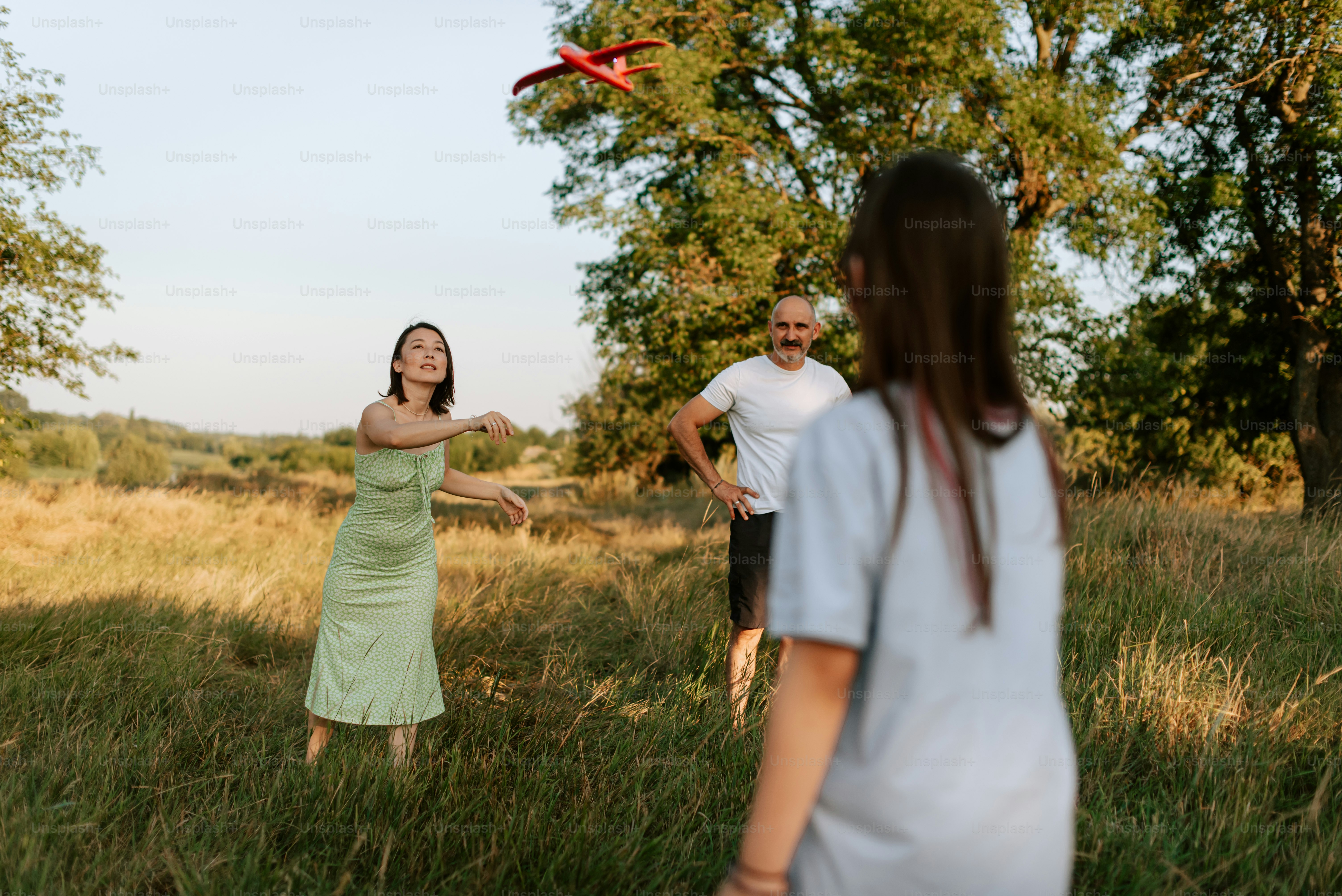 A group of people standing in a field flying a kite