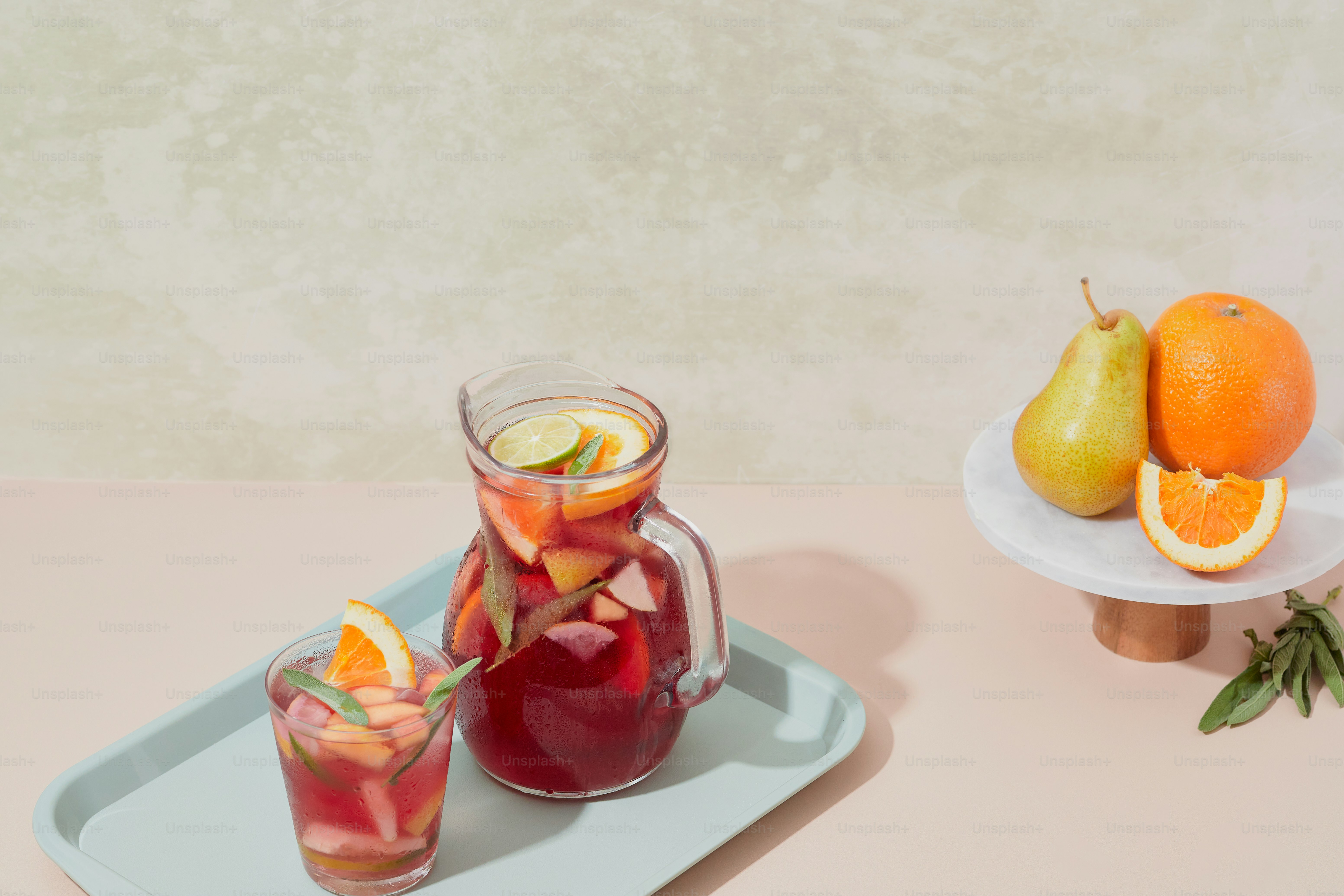 A tray with a pitcher of liquid and a plate with fruit on it