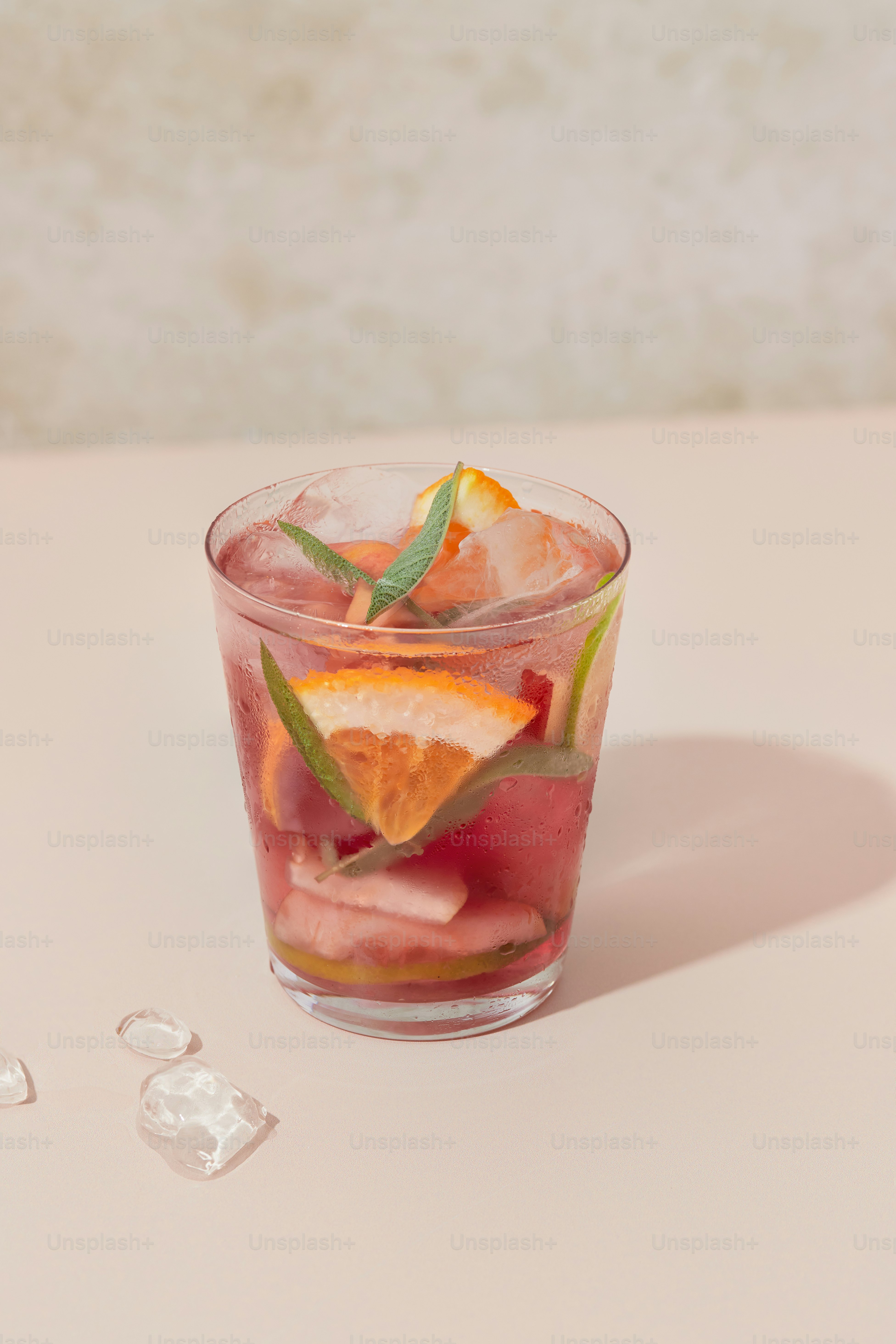 A glass filled with fruit and ice on top of a table