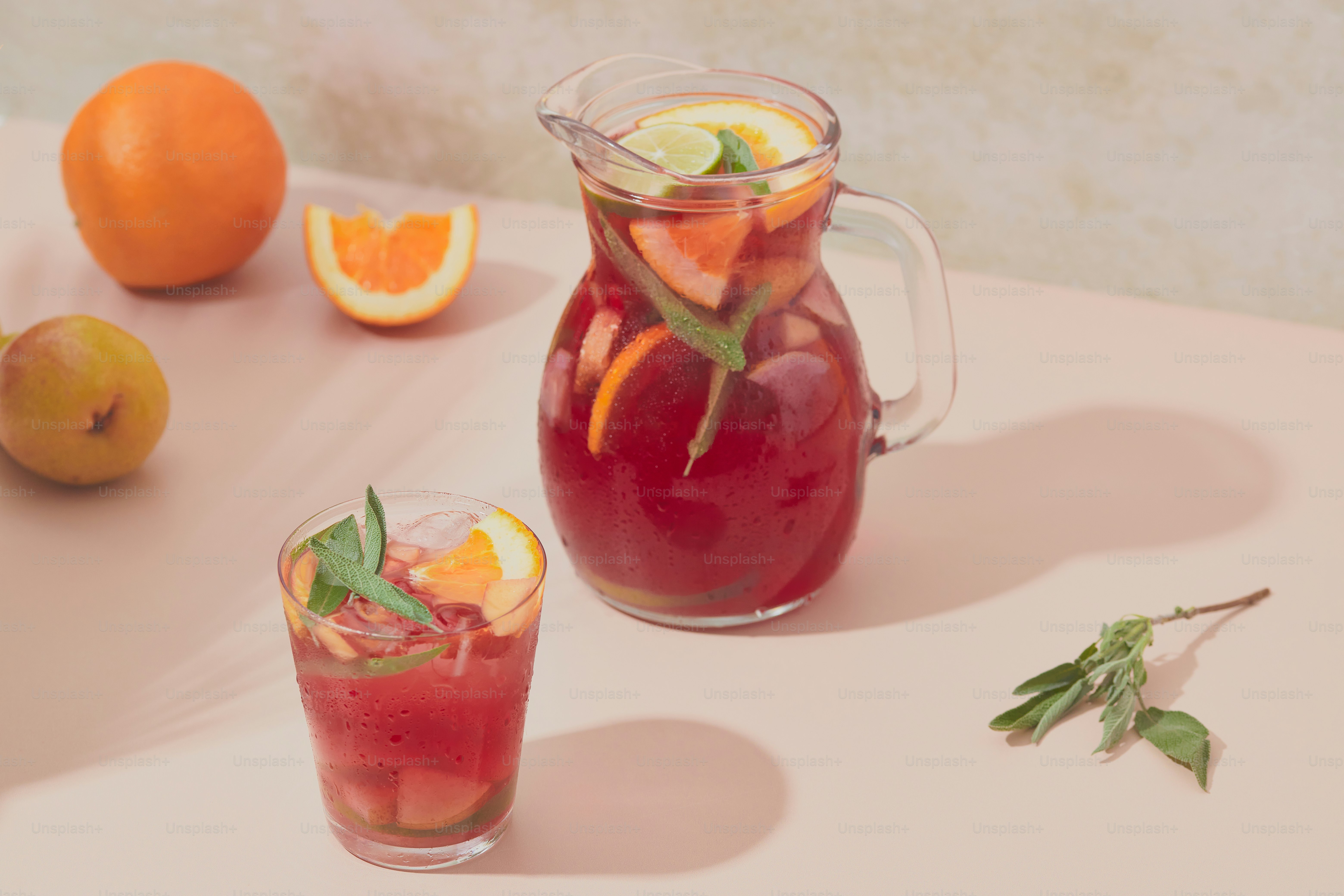 A pitcher and two glasses filled with fruit