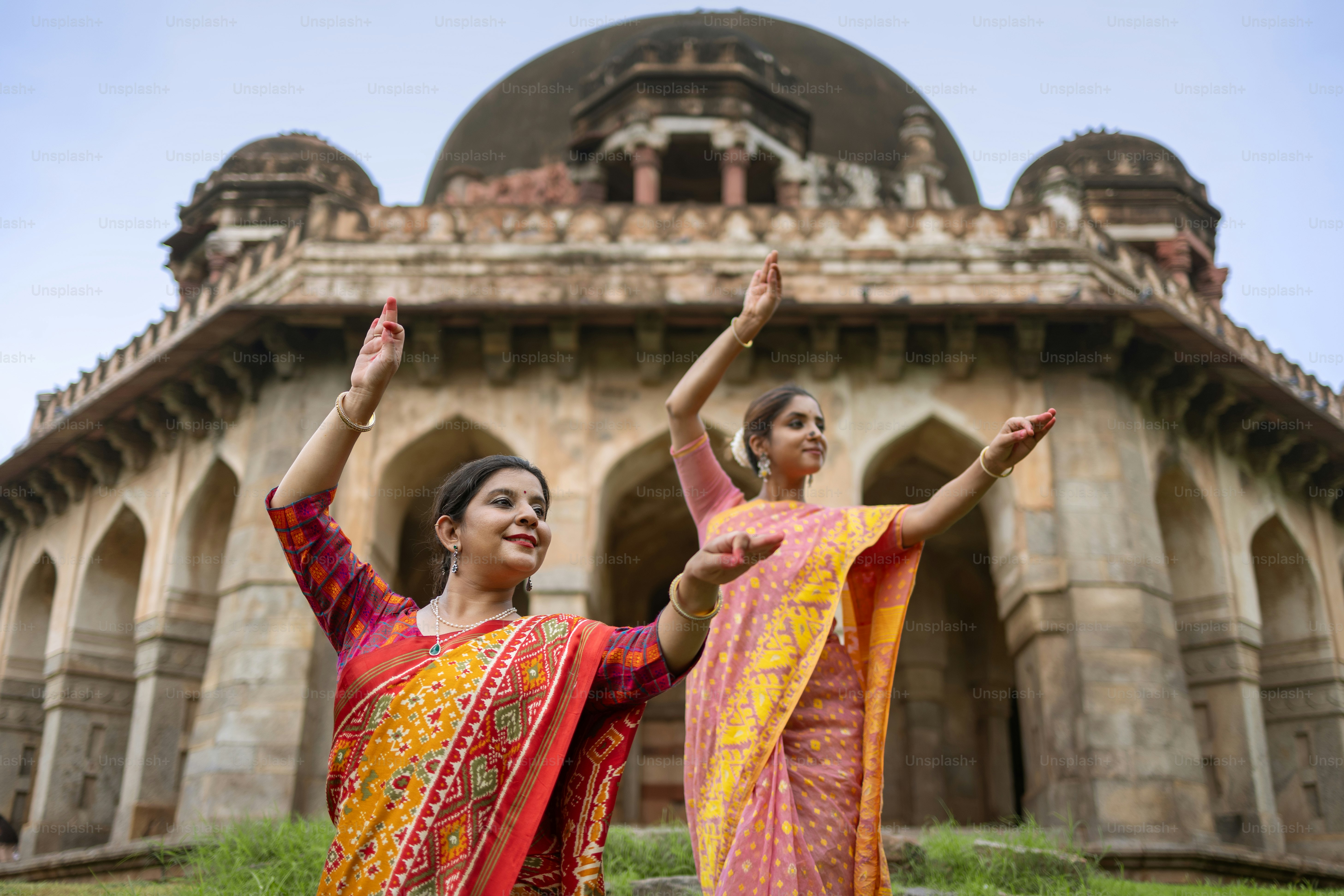 A couple of women standing next to each other in front of a building