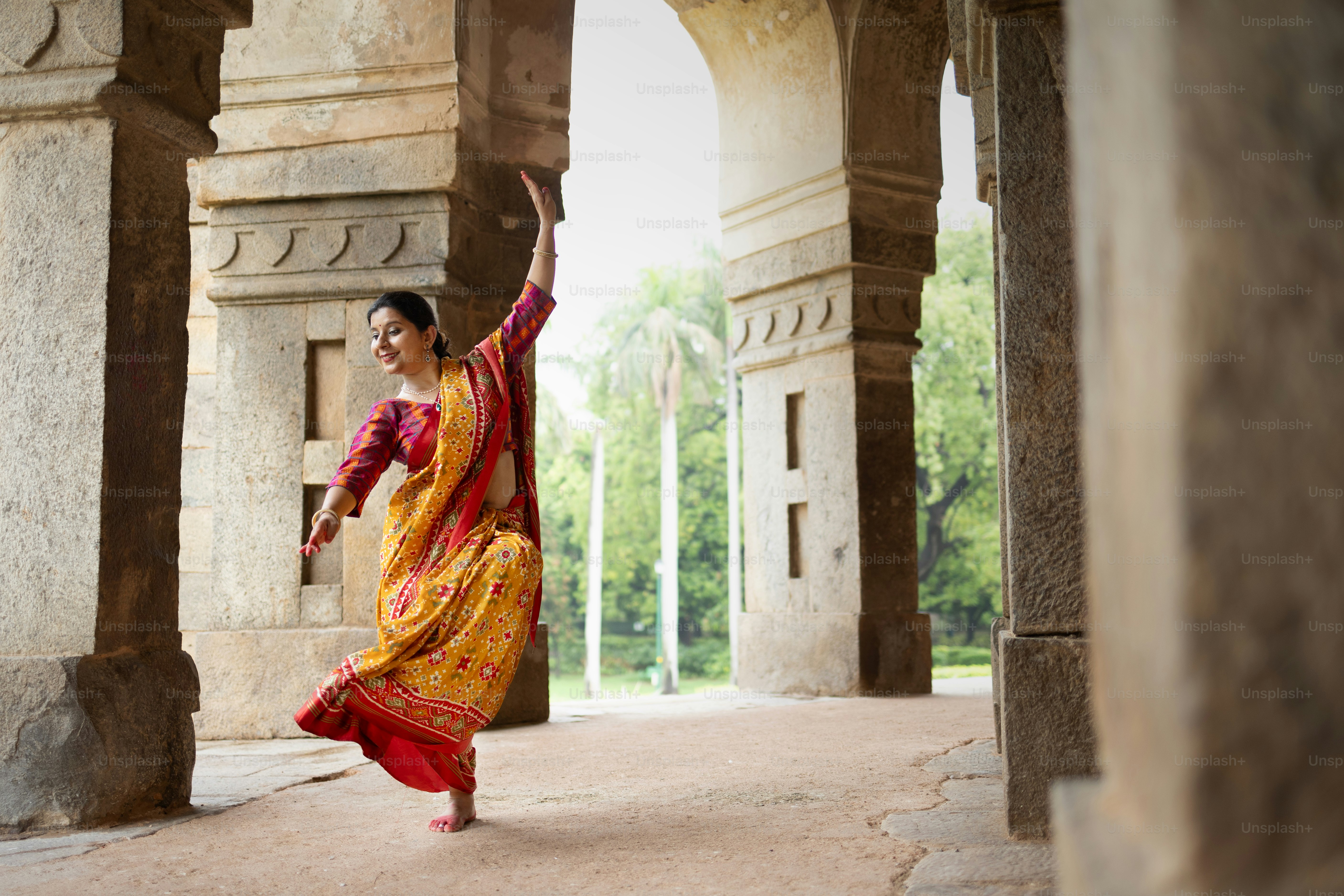 Une femme en robe jaune et rouge danse