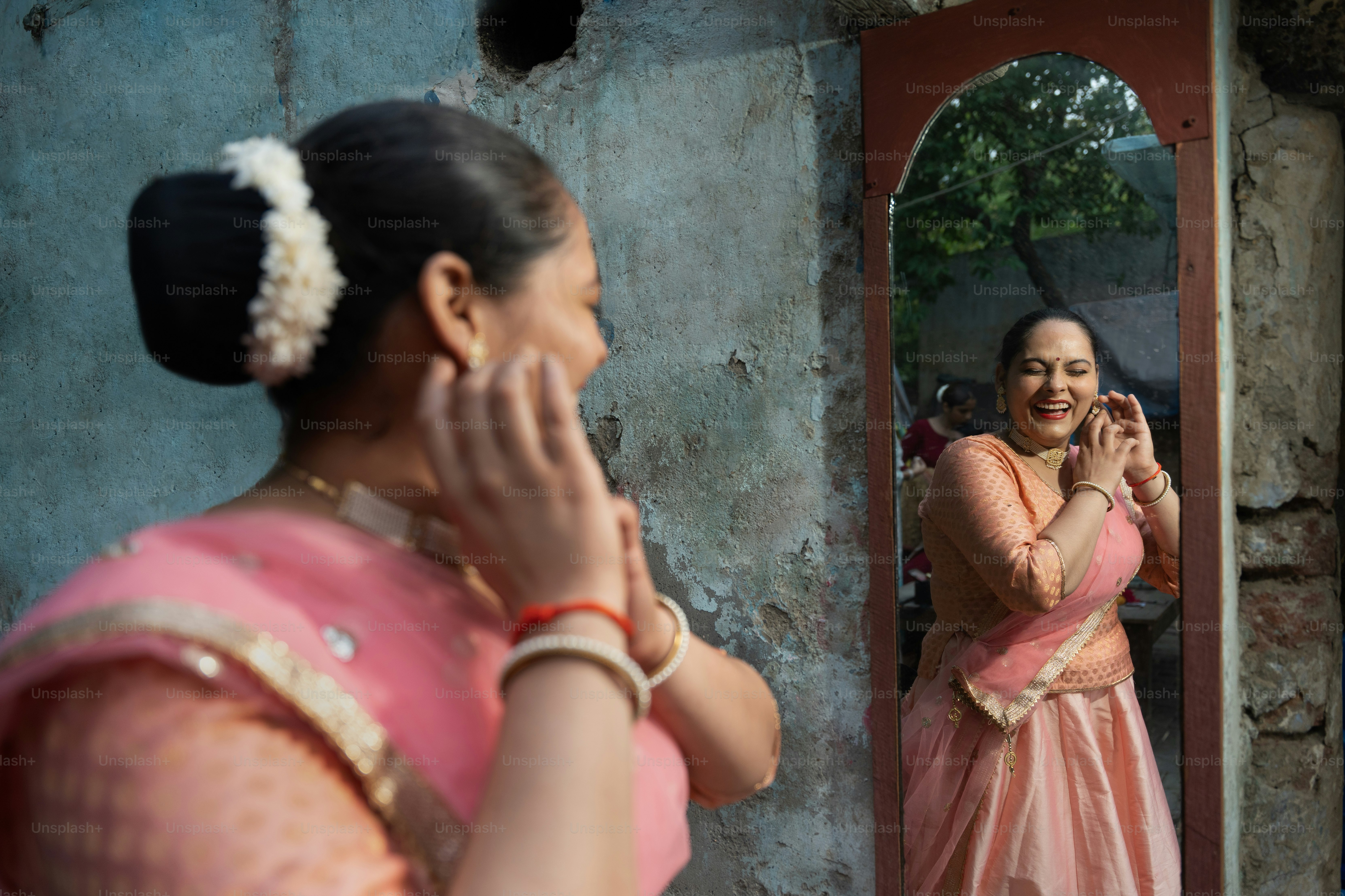 A woman standing in front of a mirror talking on a cell phone