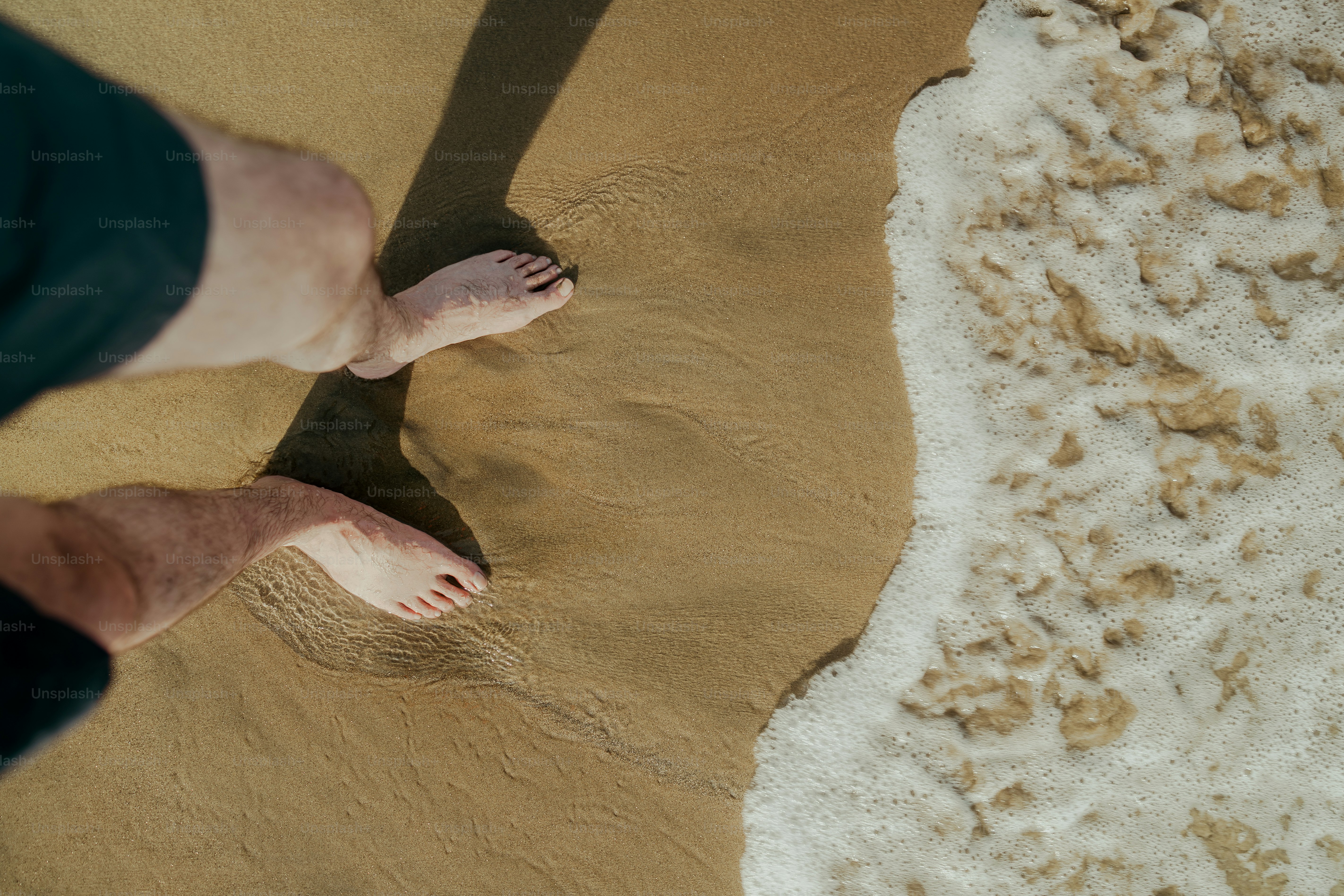 A man standing on a beach next to the ocean