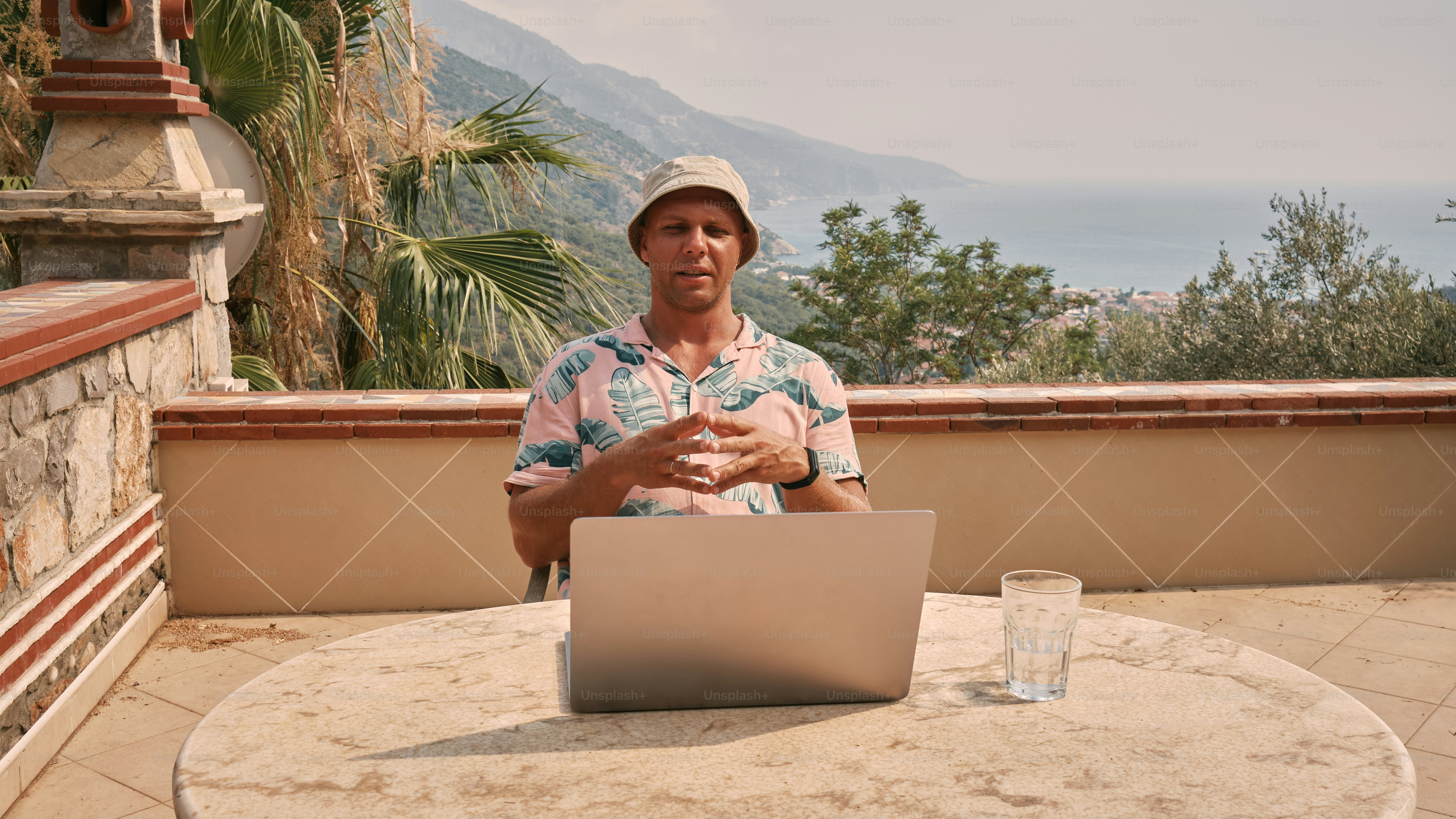 Ein Mann sitzt mit einem Laptop an einem Tisch