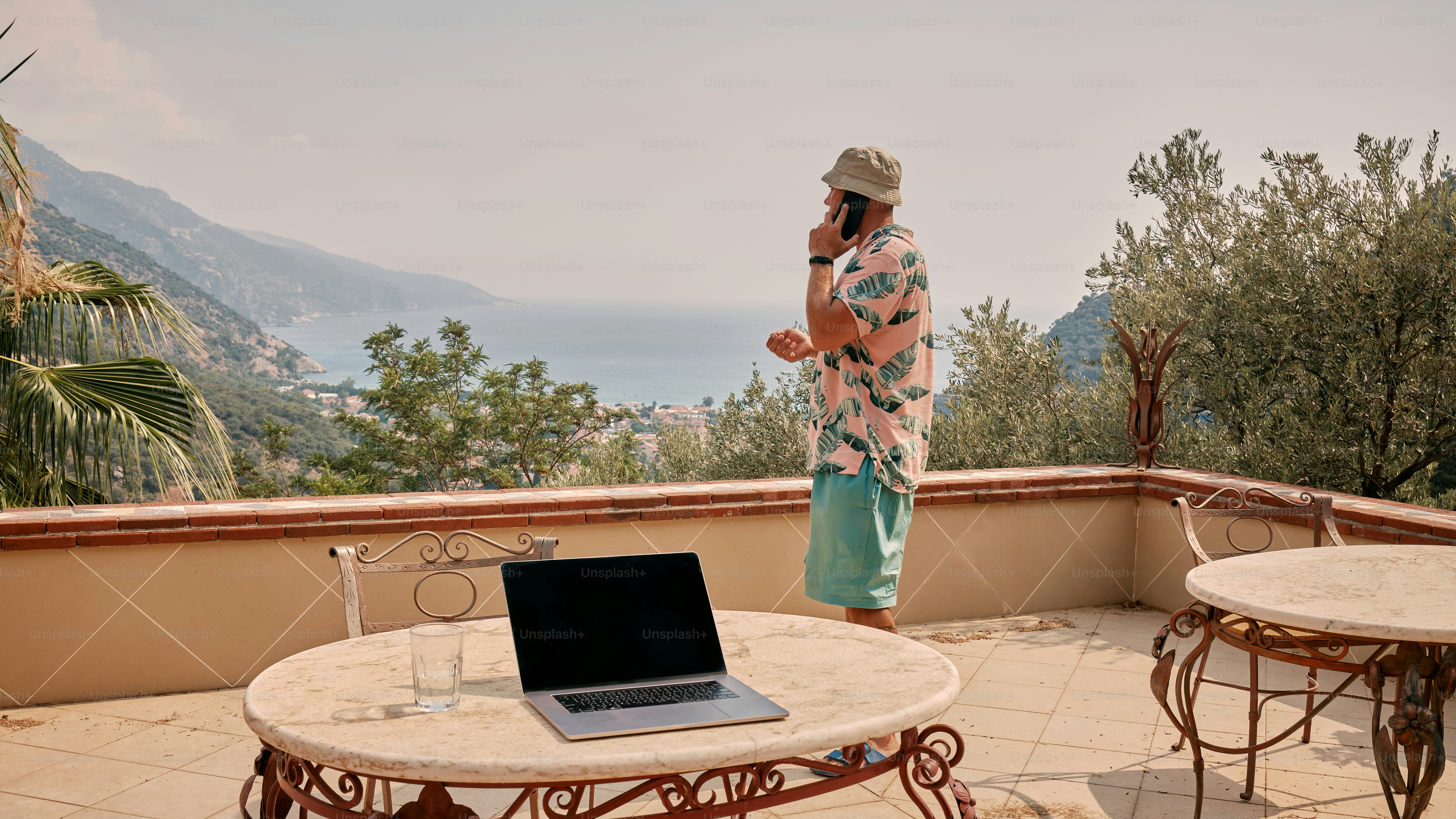 A person standing on a balcony with a laptop