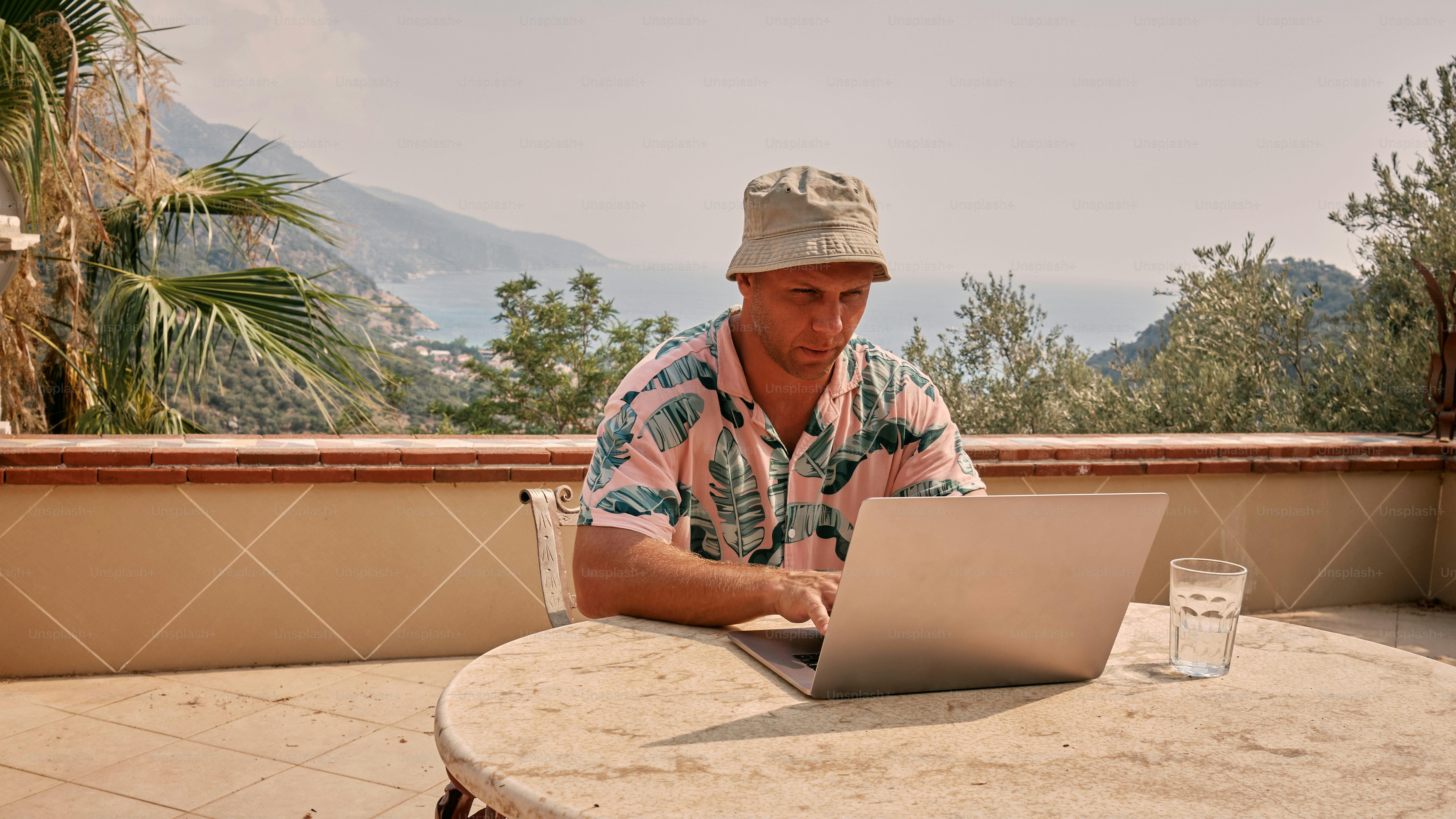 A man sitting at a table using a laptop computer