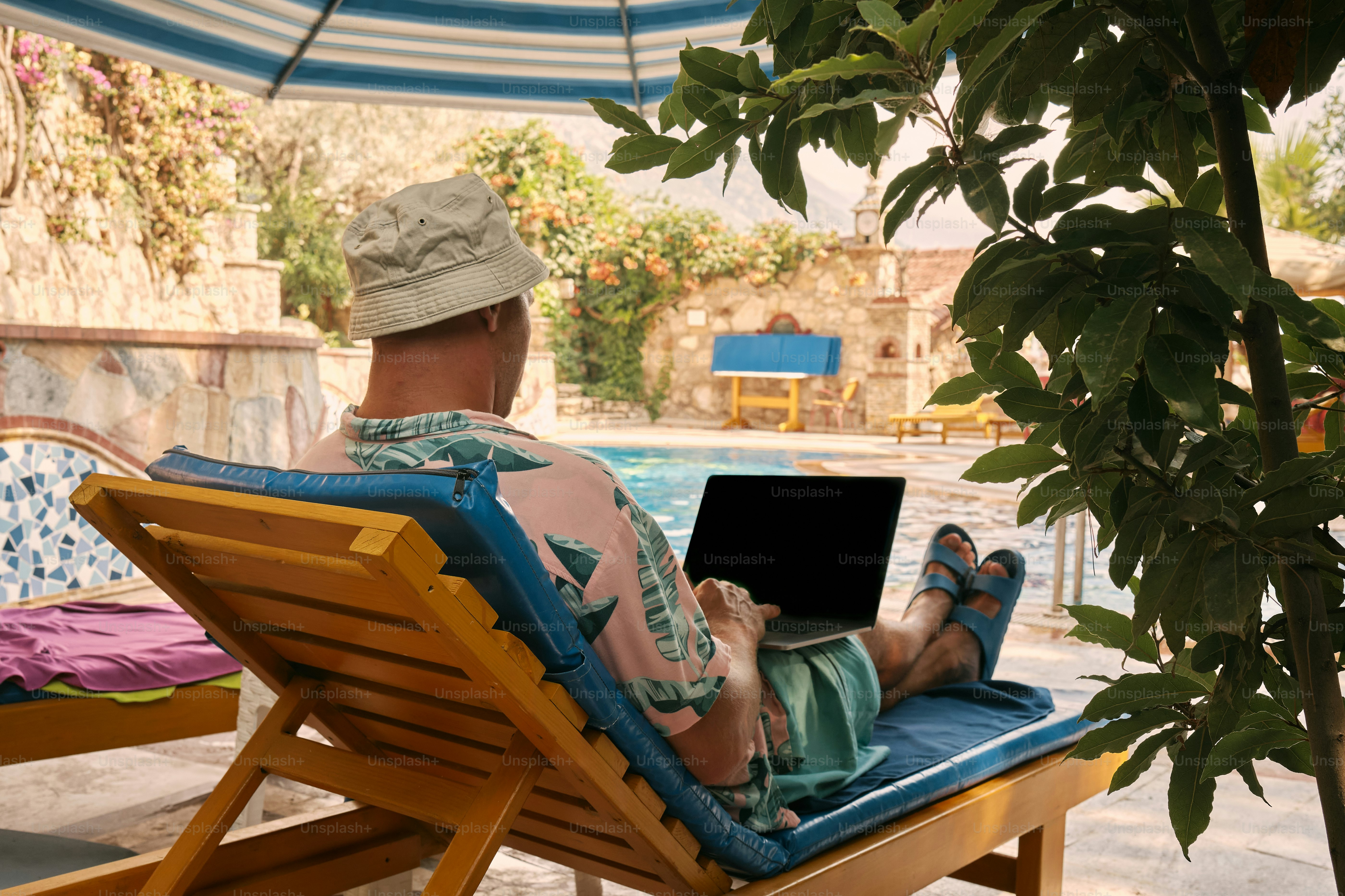 A man sitting in a chair with a laptop on his lap