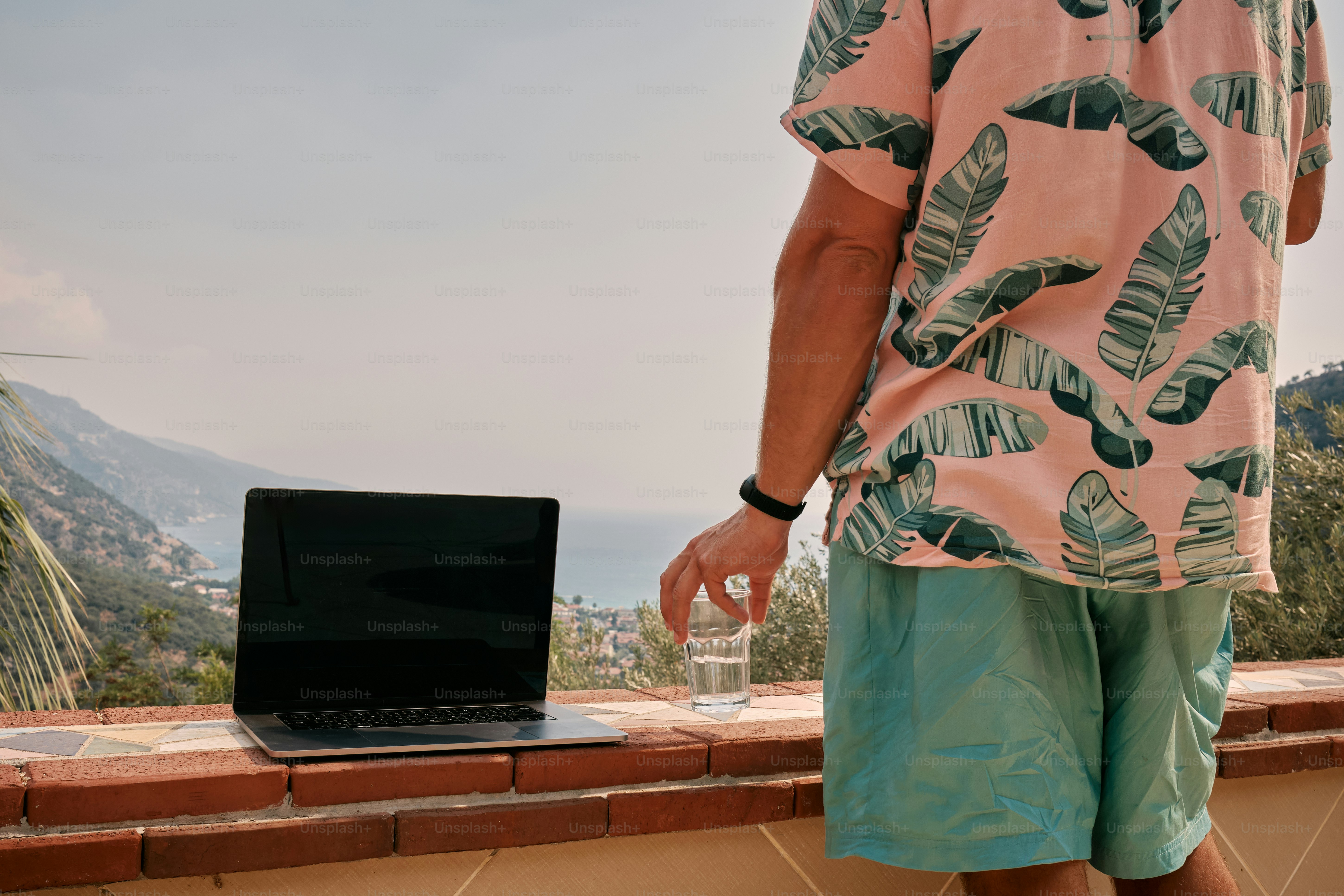 A man standing next to a laptop computer