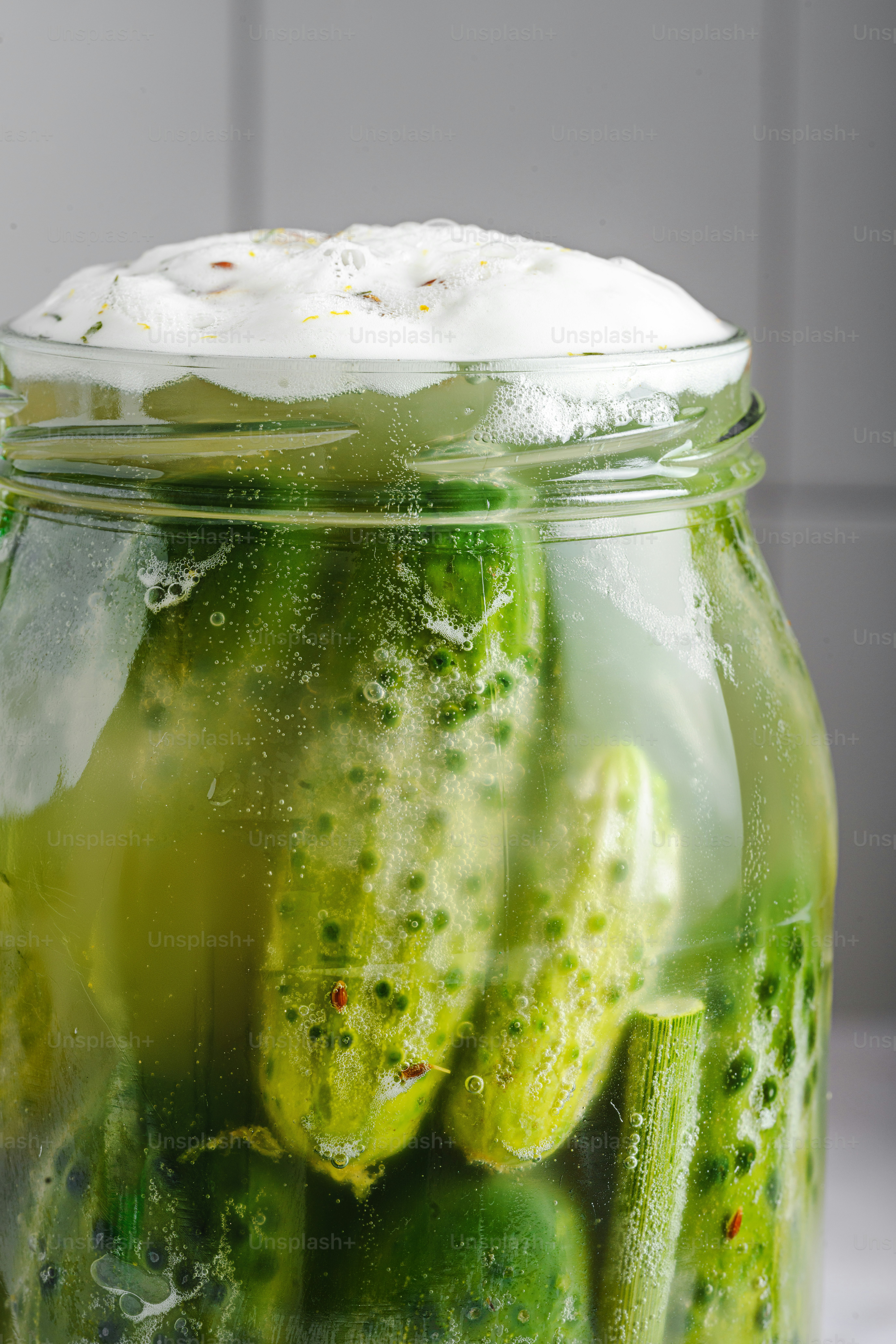 A jar filled with pickles sitting on top of a counter