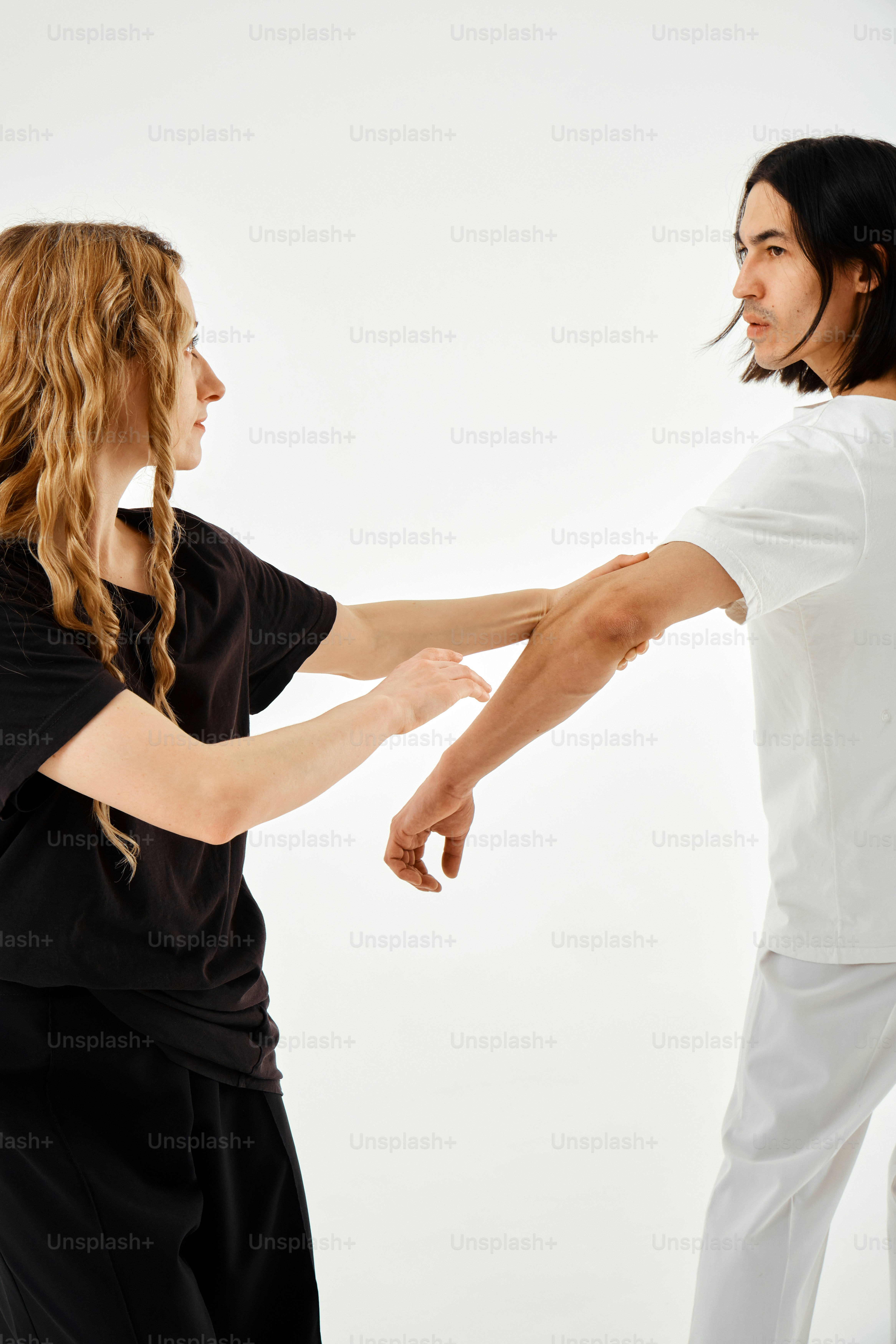 A man and a woman standing in front of a white background