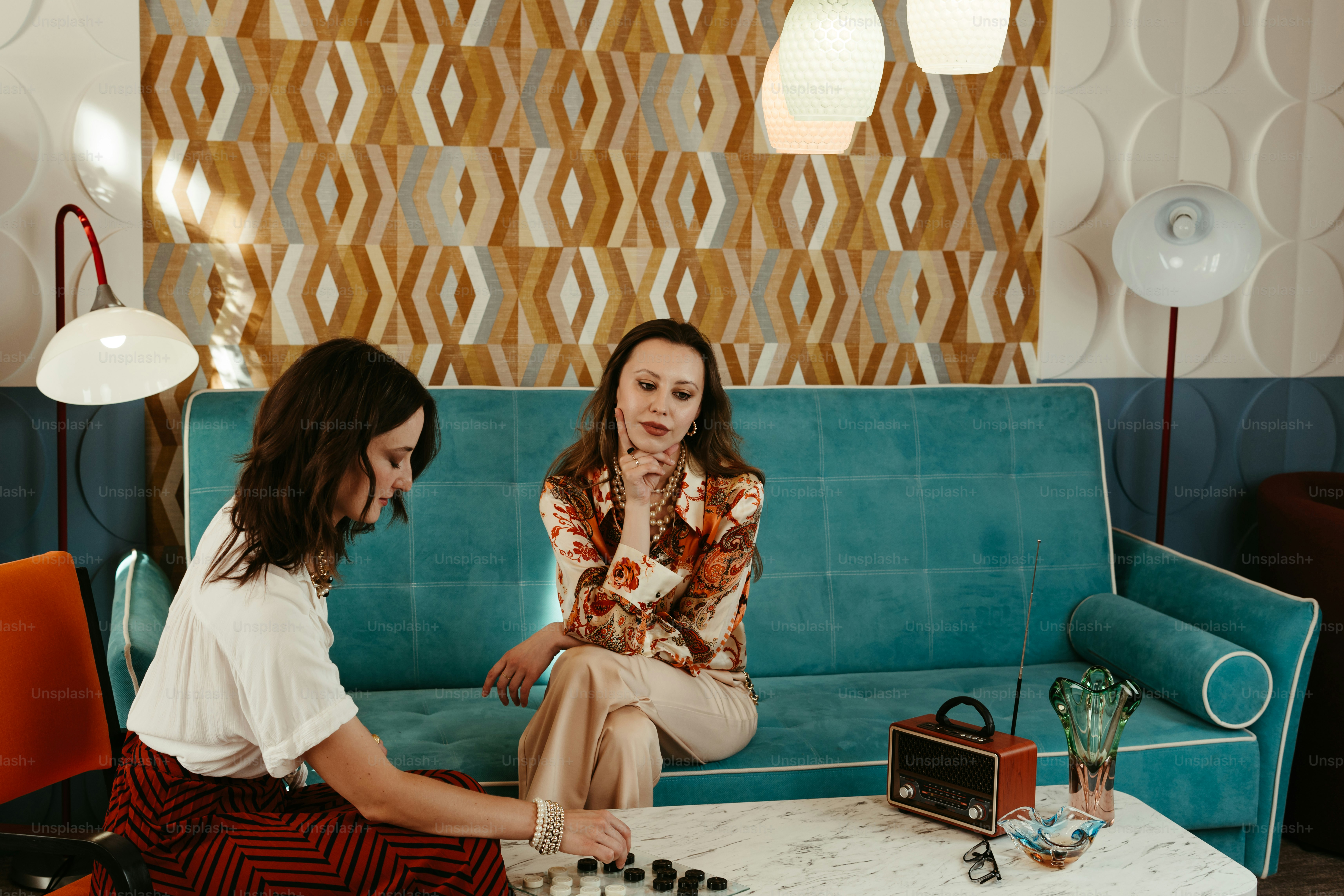 A couple of women sitting on top of a blue couch