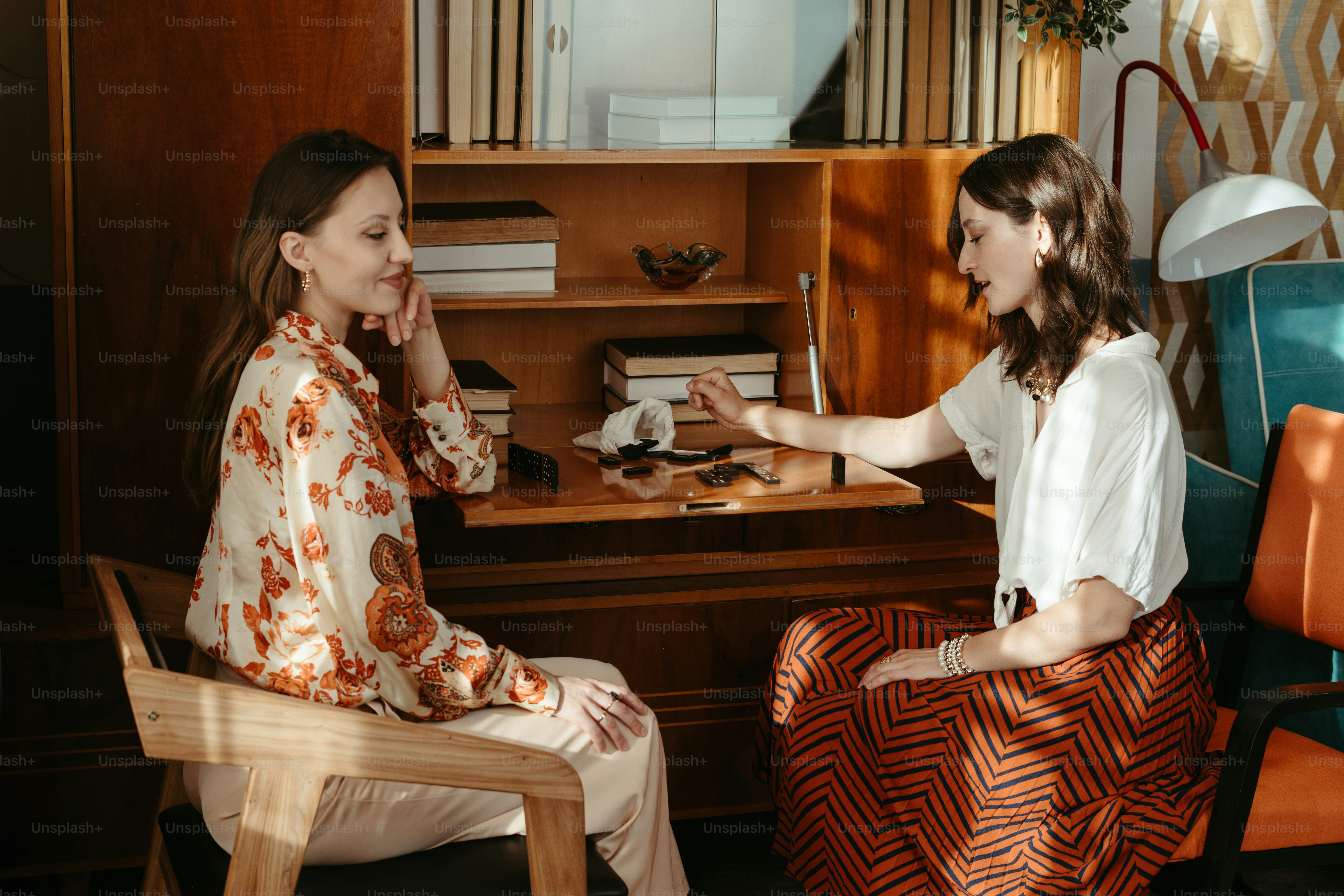 Two women sitting at a desk talking to each other