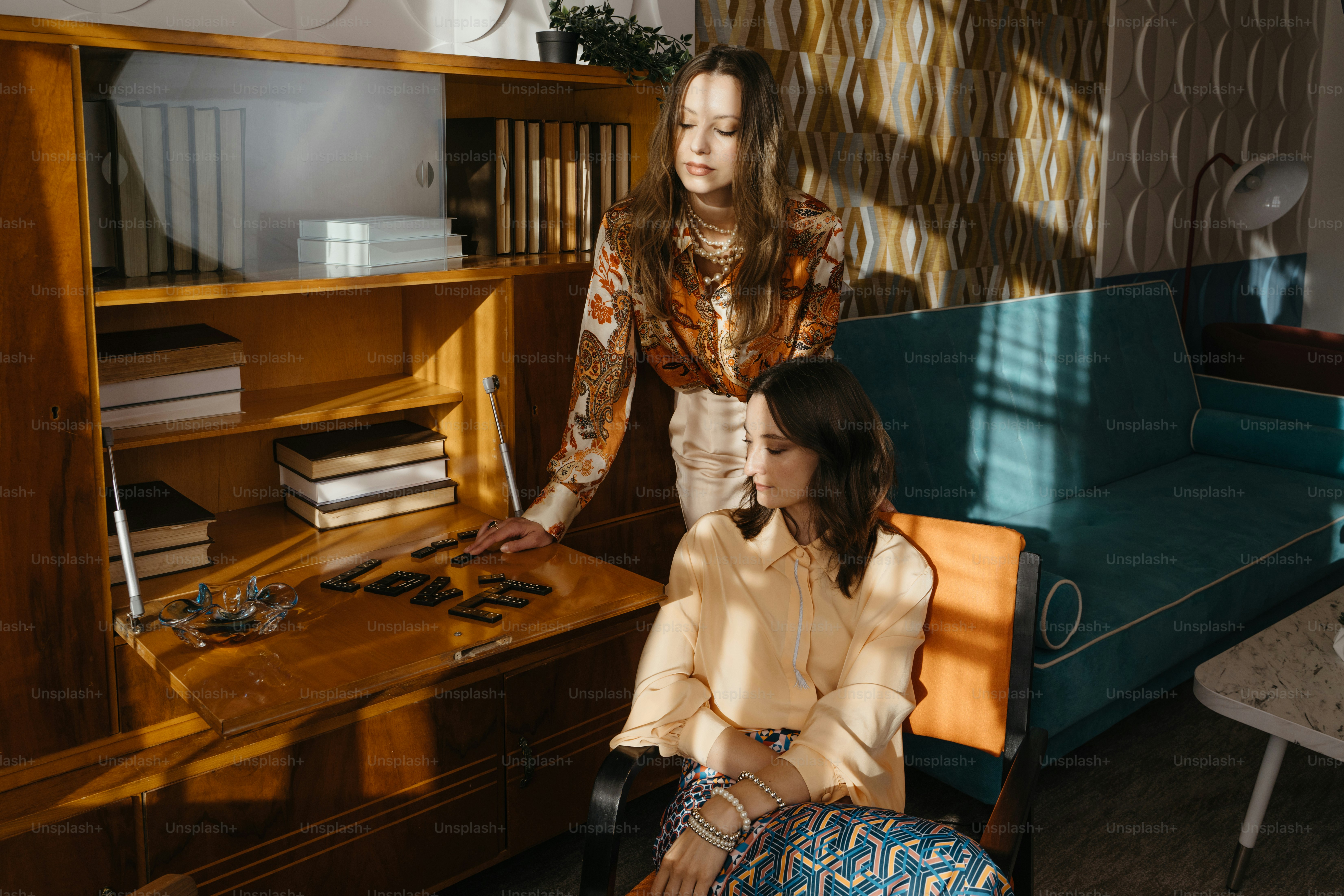 Una donna seduta su una sedia accanto a una donna in piedi in un soggiorno