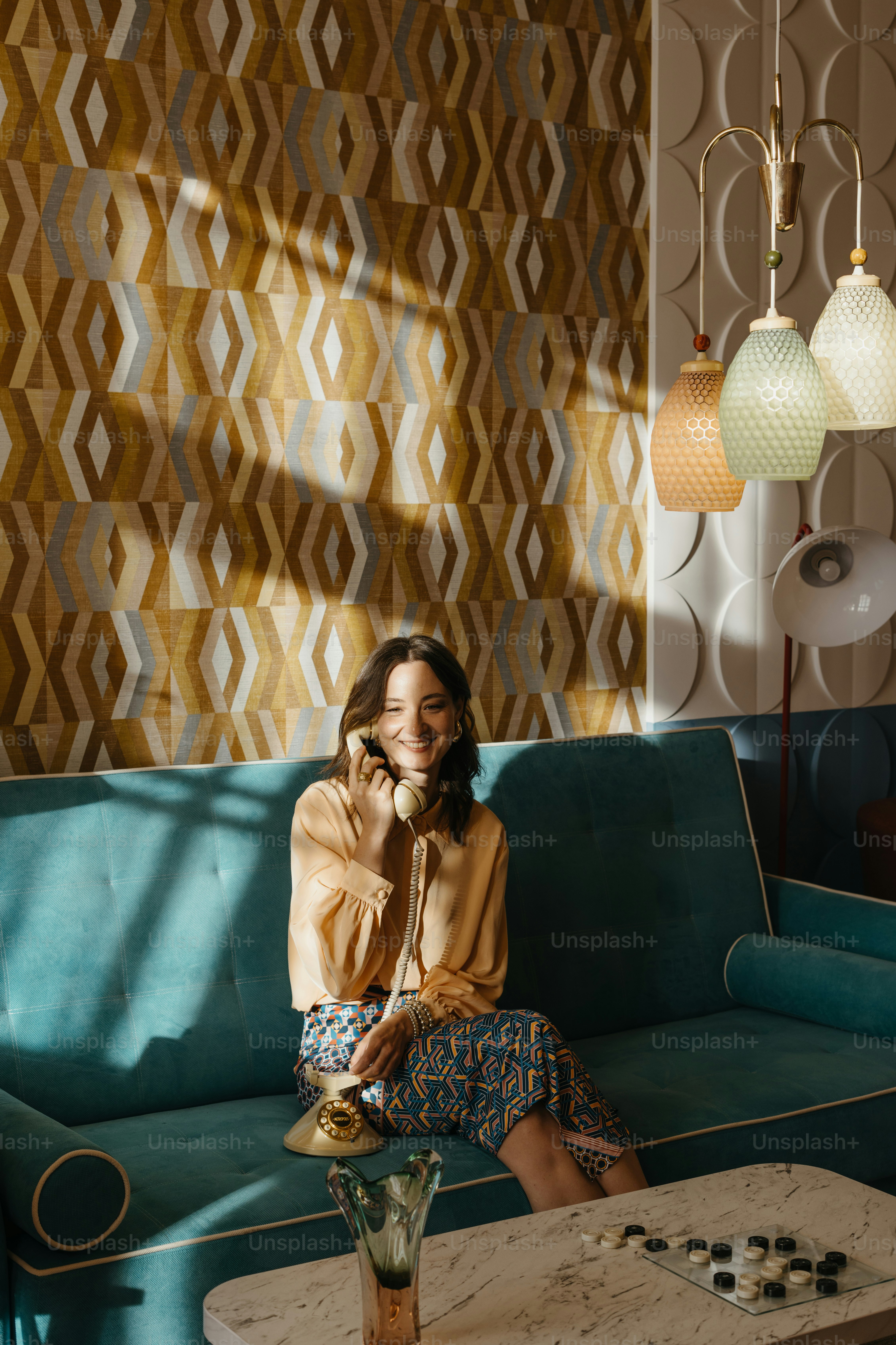 A woman sitting on a couch talking on a cell phone