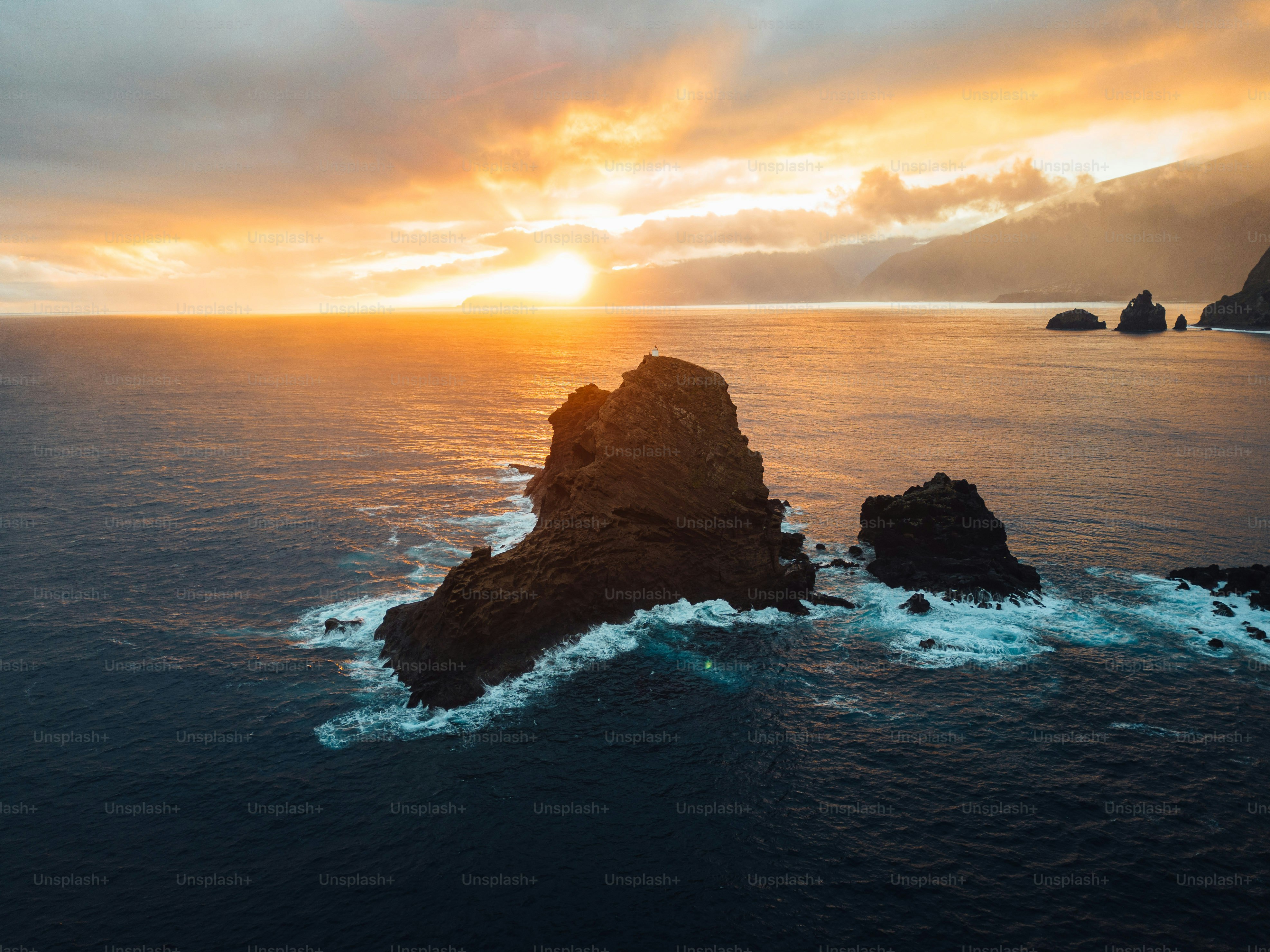 A large rock in the middle of a body of water