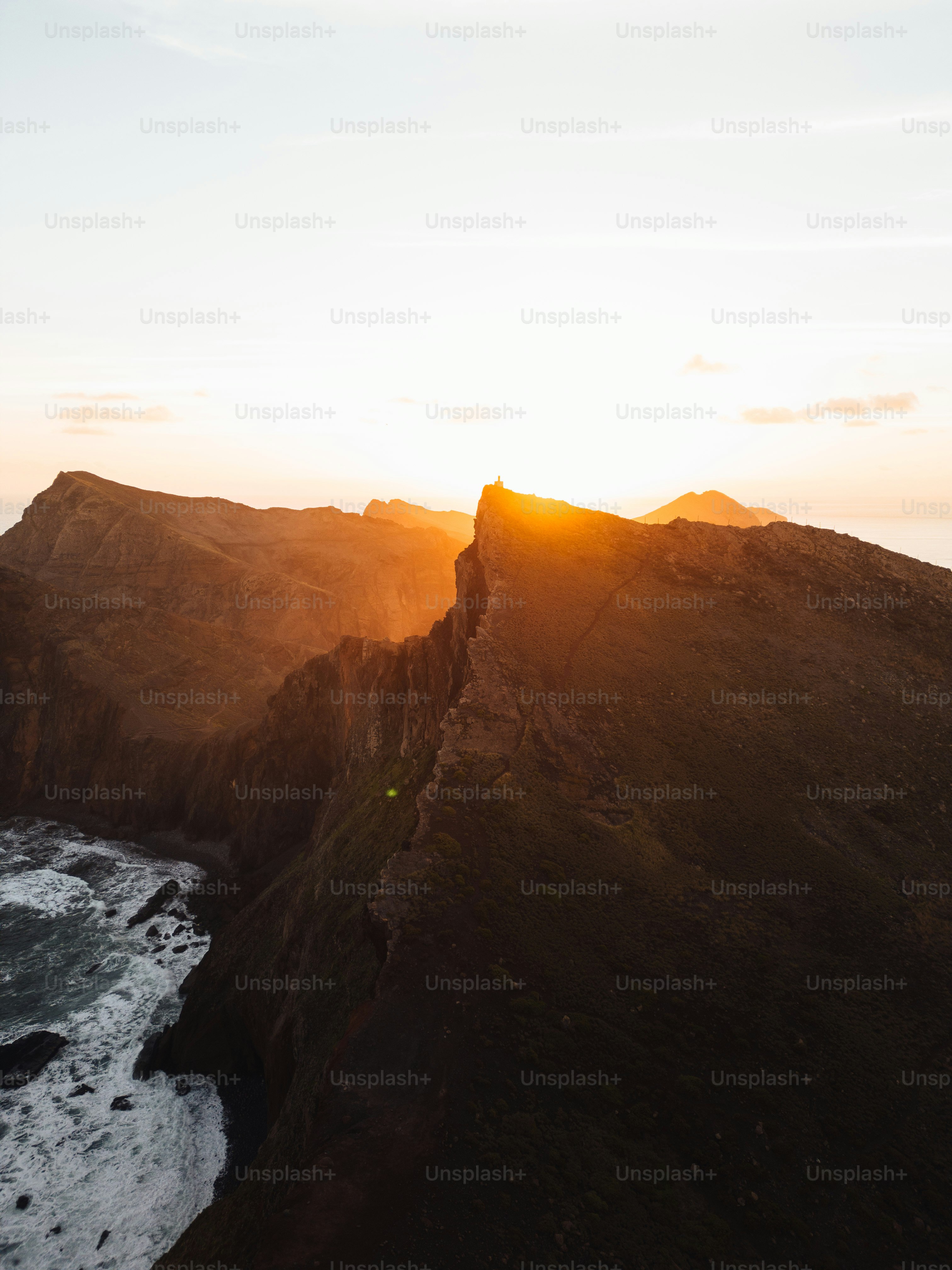 The sun is setting over a rocky mountain