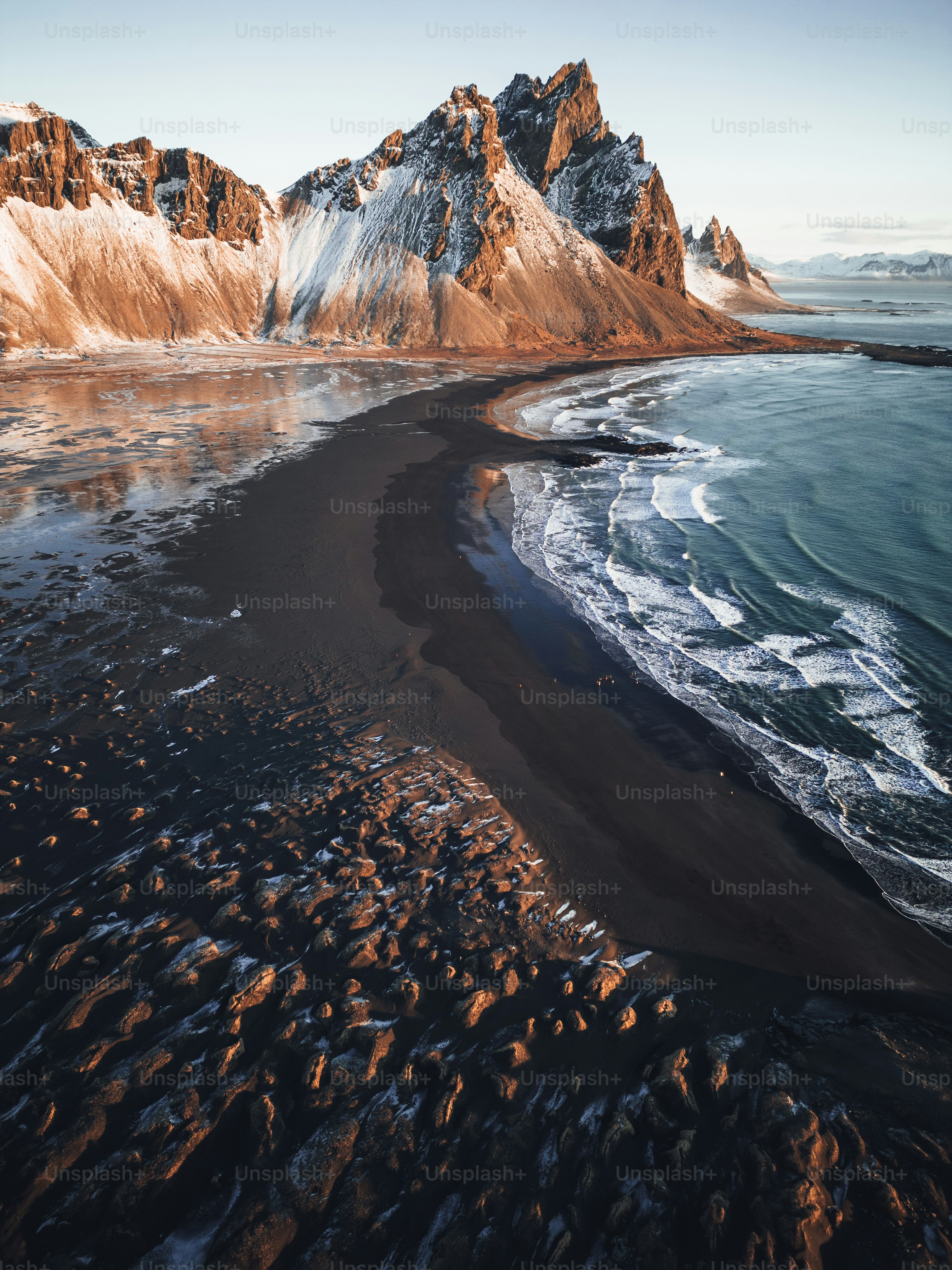 An aerial view of a beach with mountains in the background