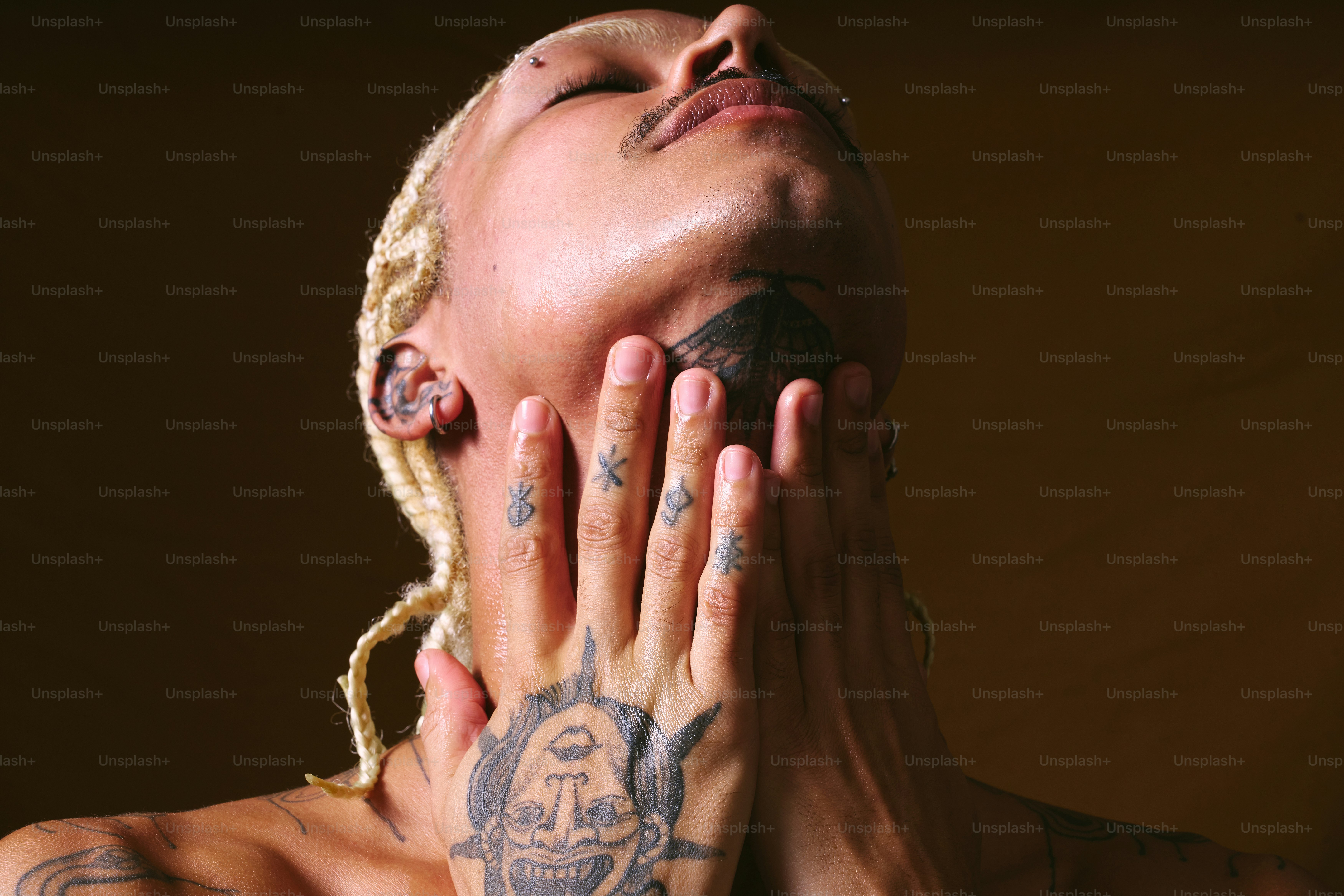 Une femme tatouée couvrant son visage avec ses mains