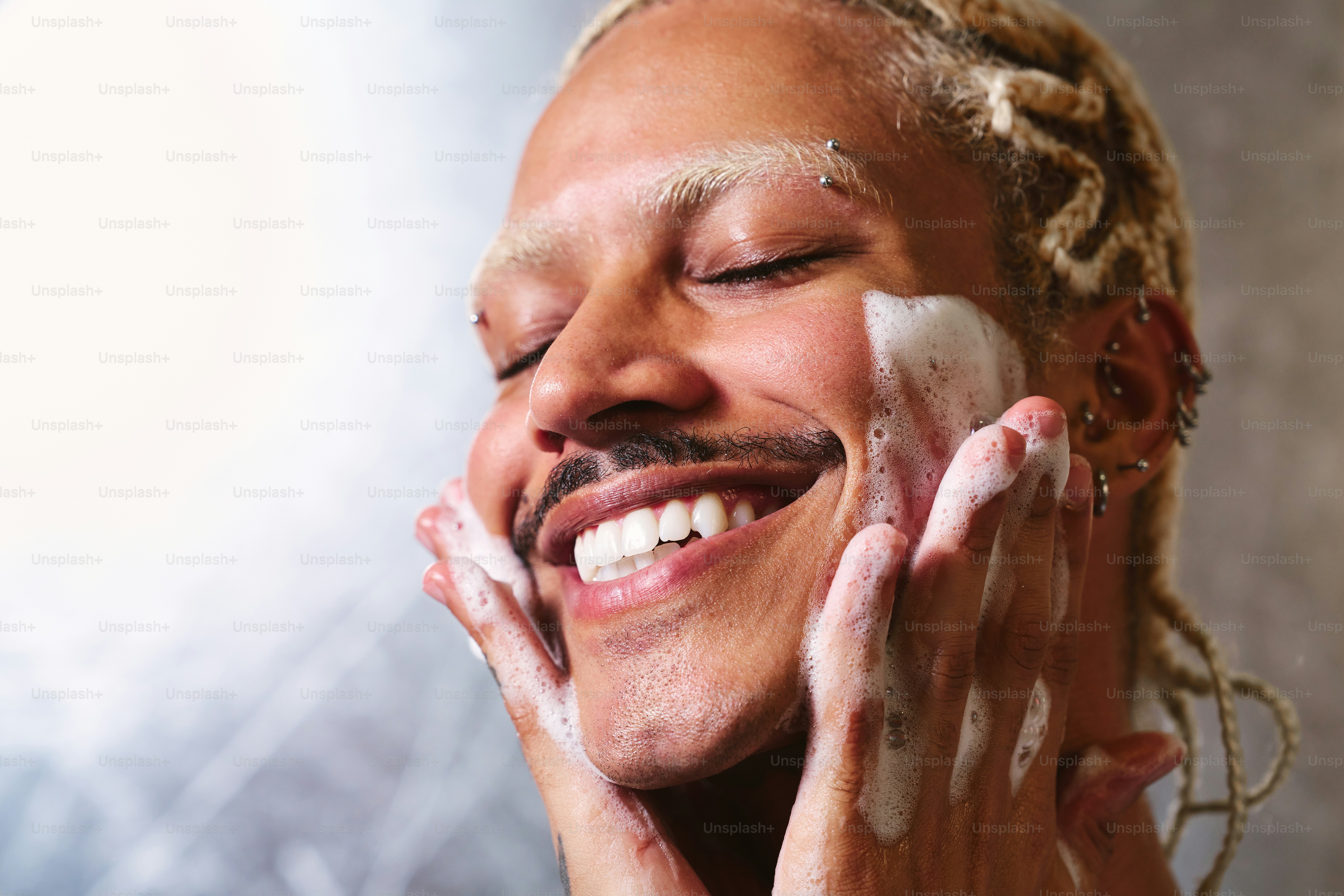 A woman is smiling while shaving her face