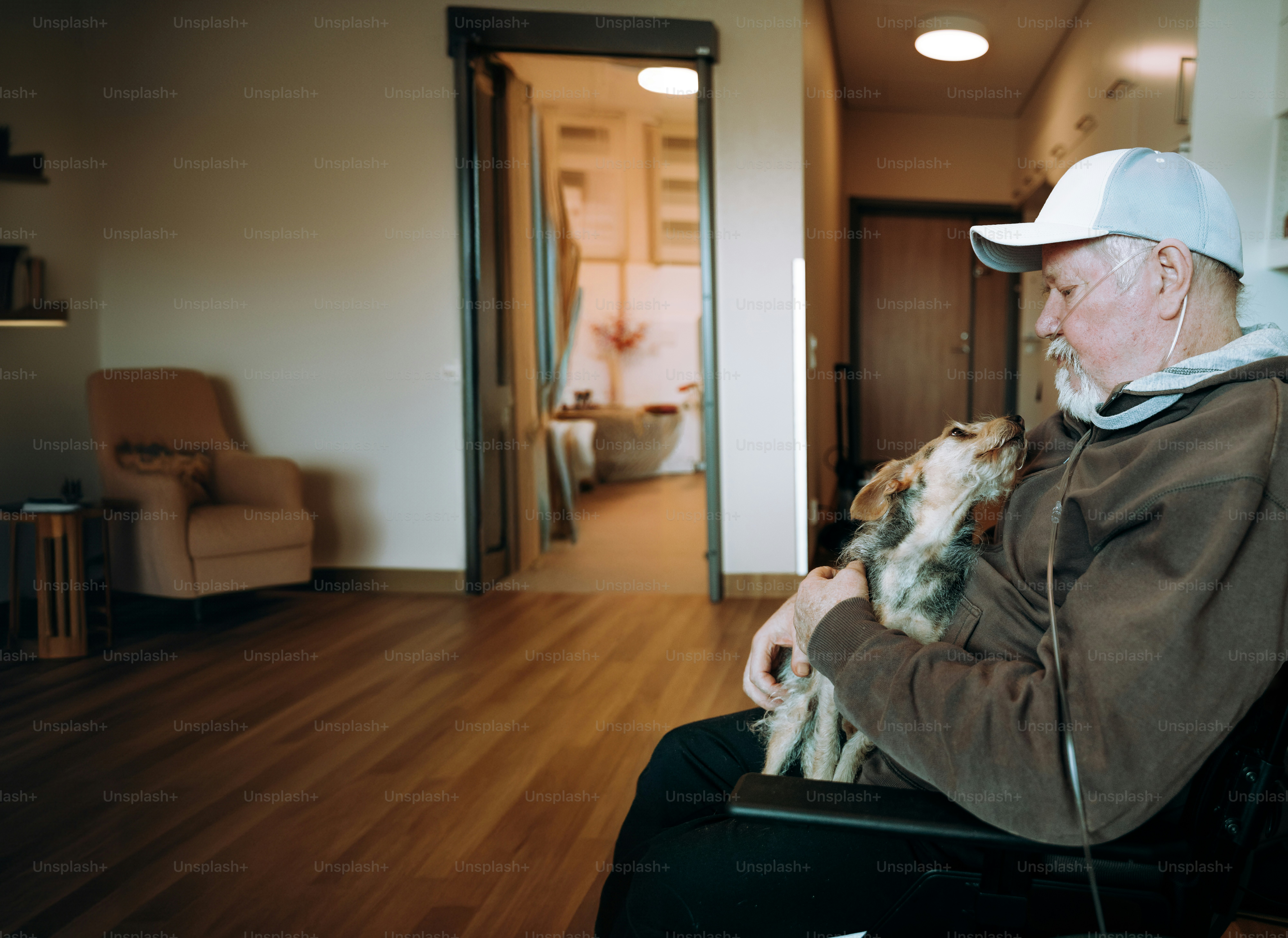 A man sitting in a chair holding a dog
