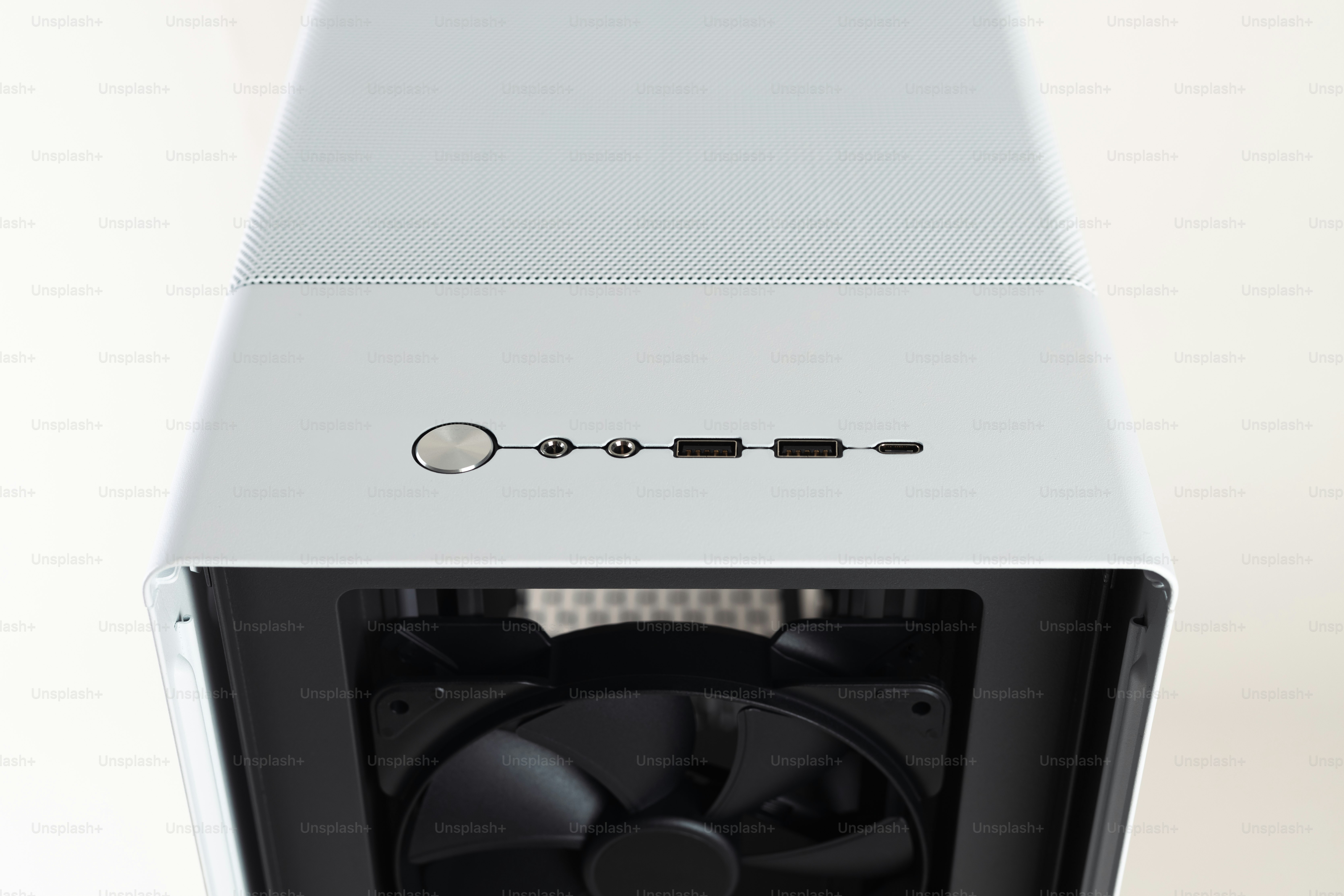 A white computer case with a fan on top of it