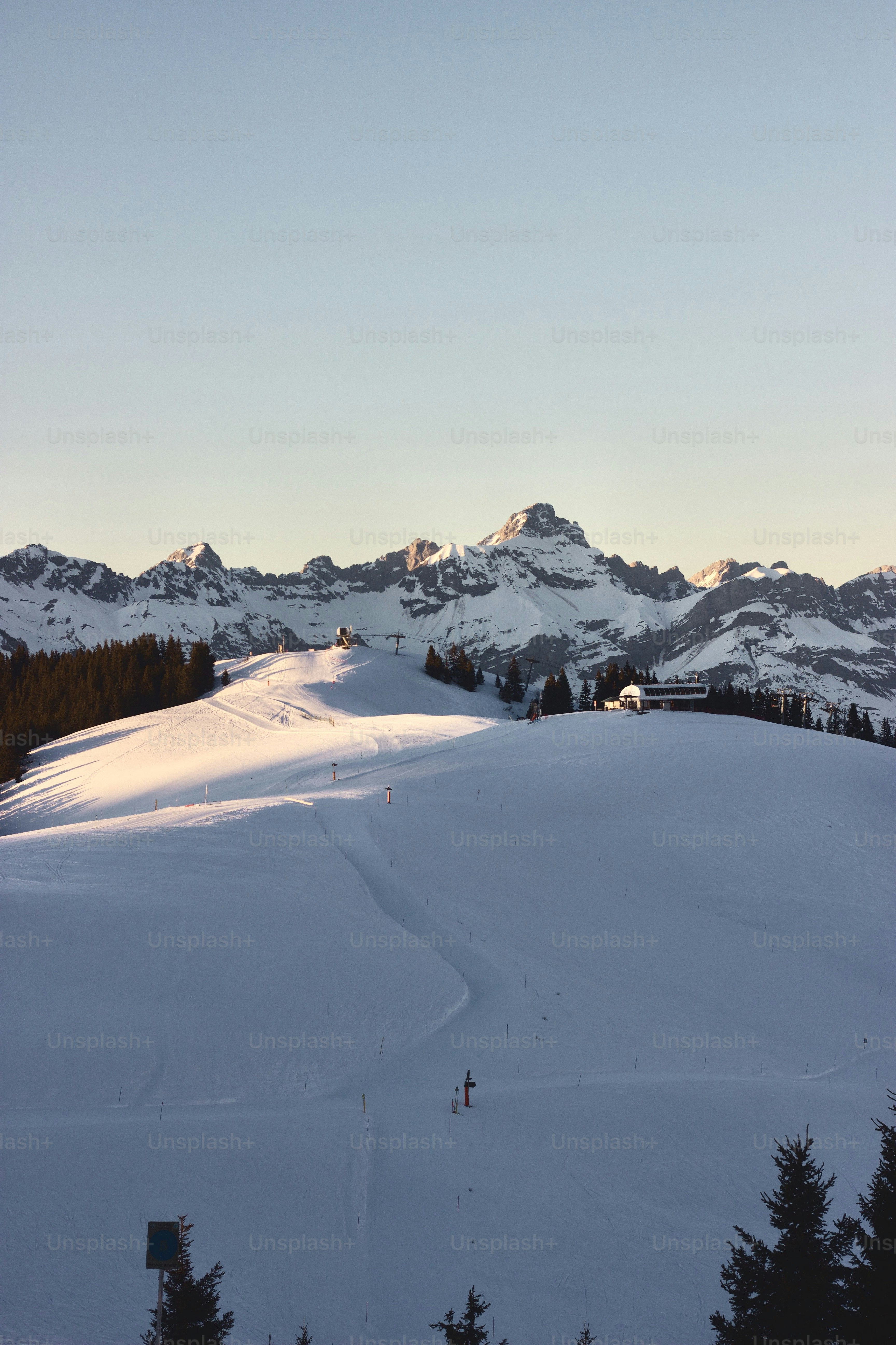 A snow covered ski slope with mountains in the background