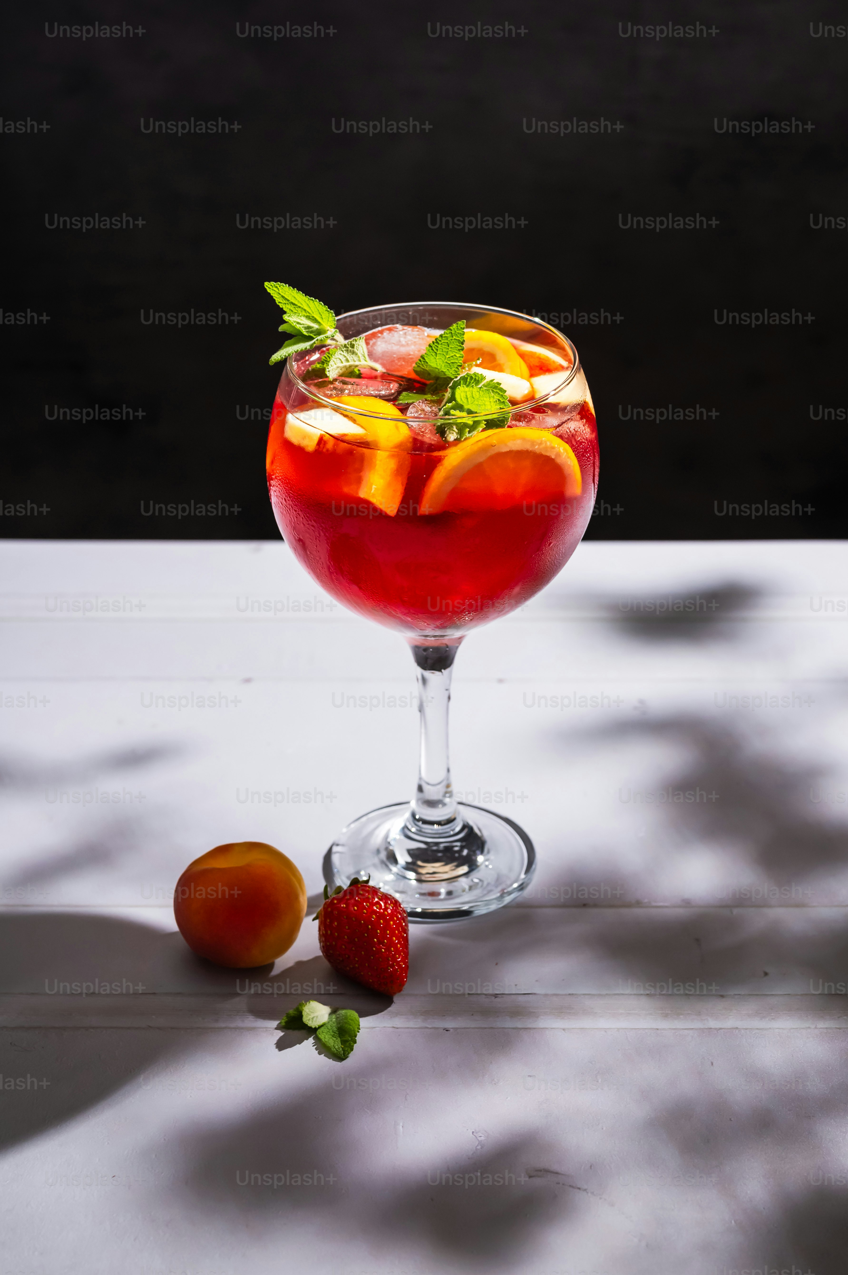 A glass filled with a drink next to some fruit