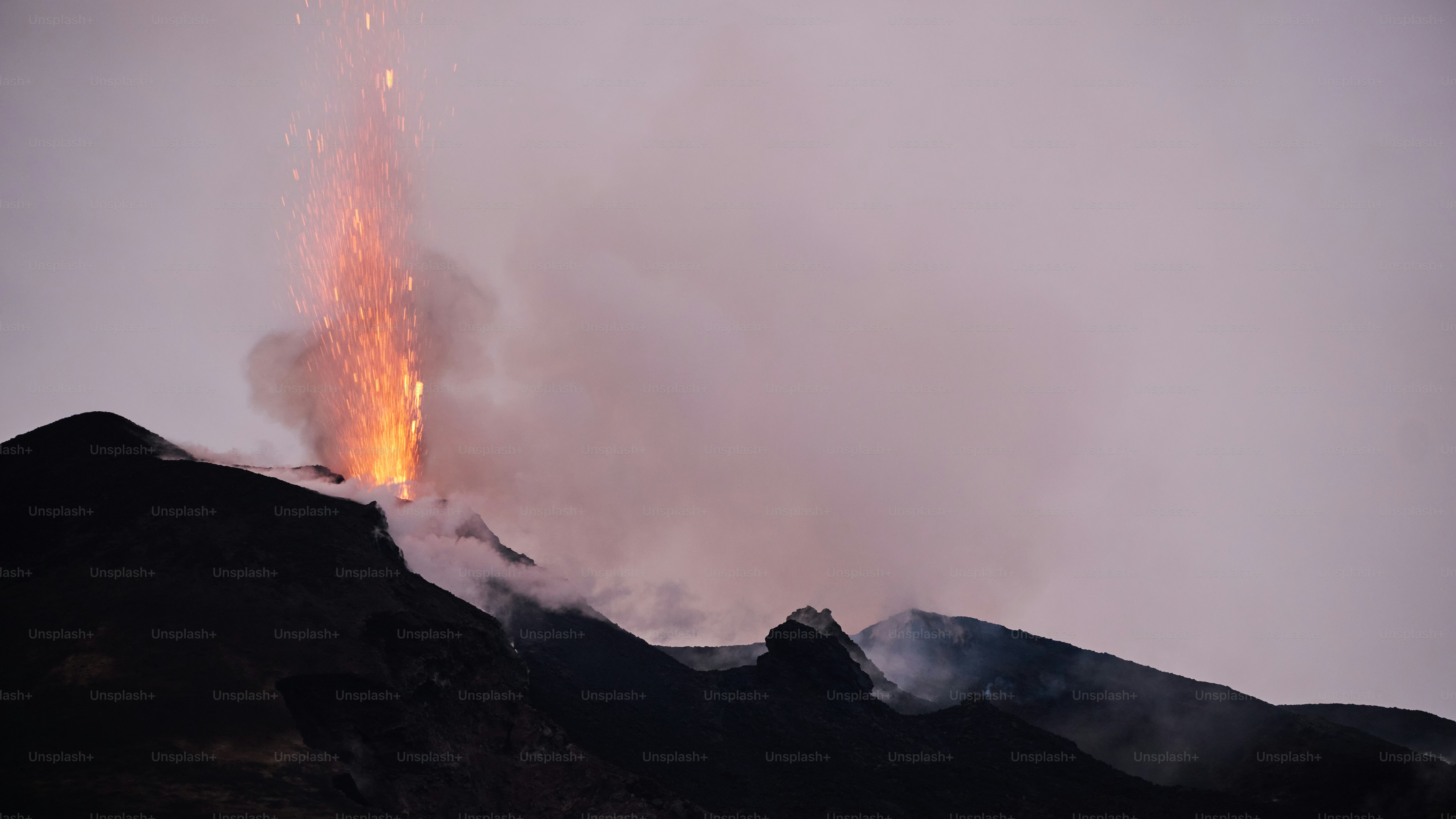 A large plume of smoke rising from the top of a mountain