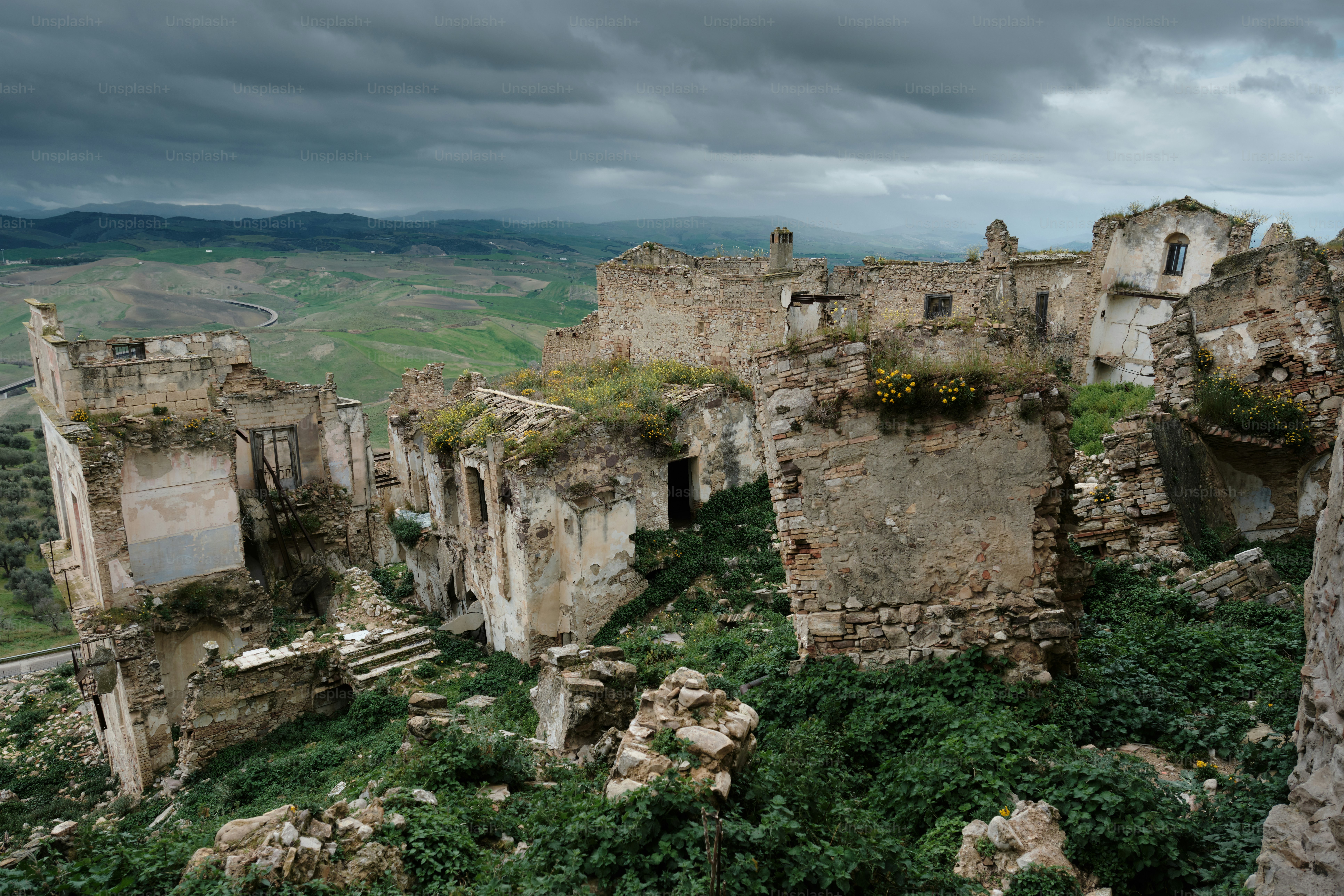 Foto Reruntuhan bangunan di atas bukit di bawah langit mendung – Gambar  Italia di Unsplash