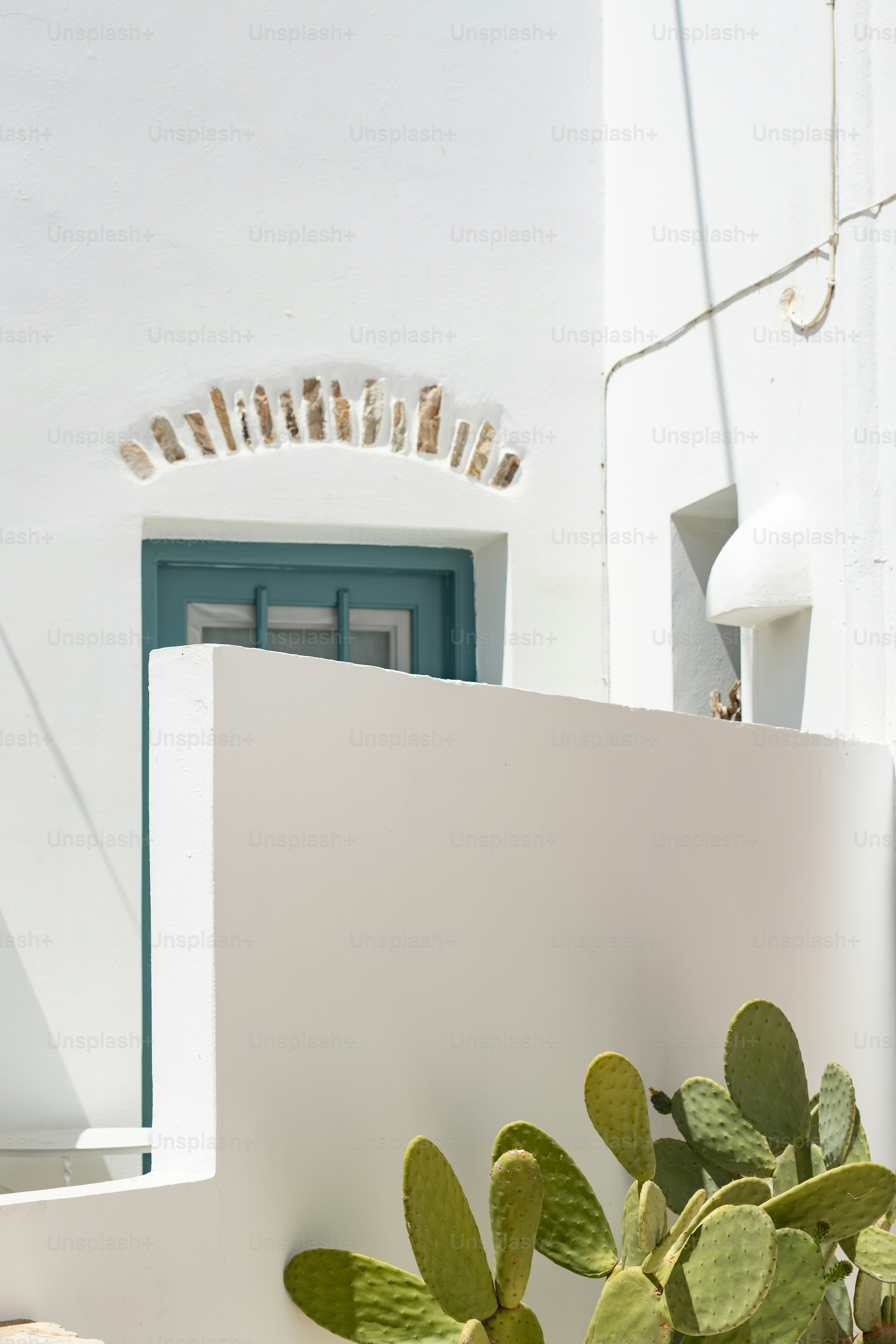 Un bâtiment blanc avec une porte et une fenêtre vertes