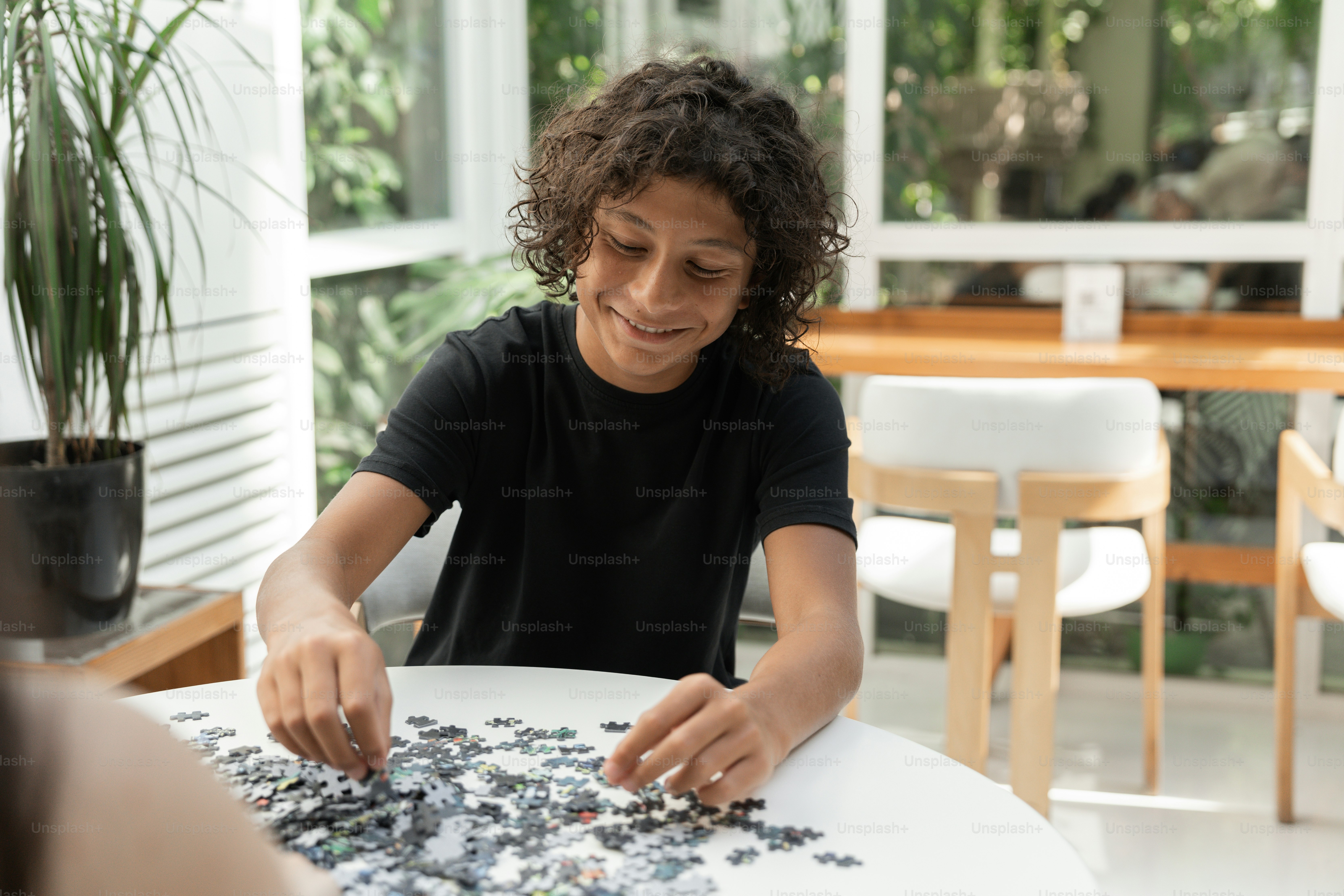 A woman sitting at a table playing with a puzzle