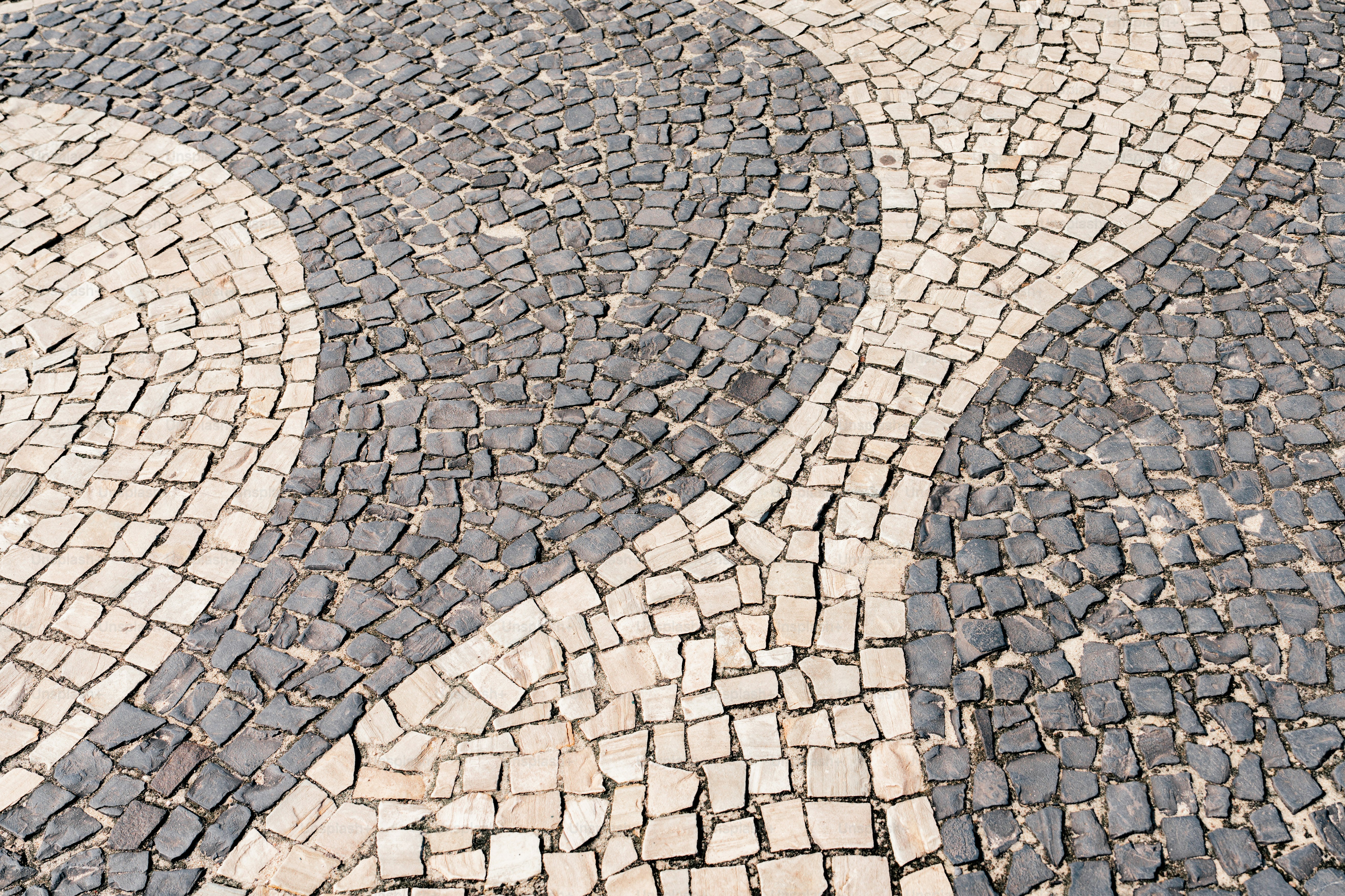 A cobblestone street with a clock tower in the background