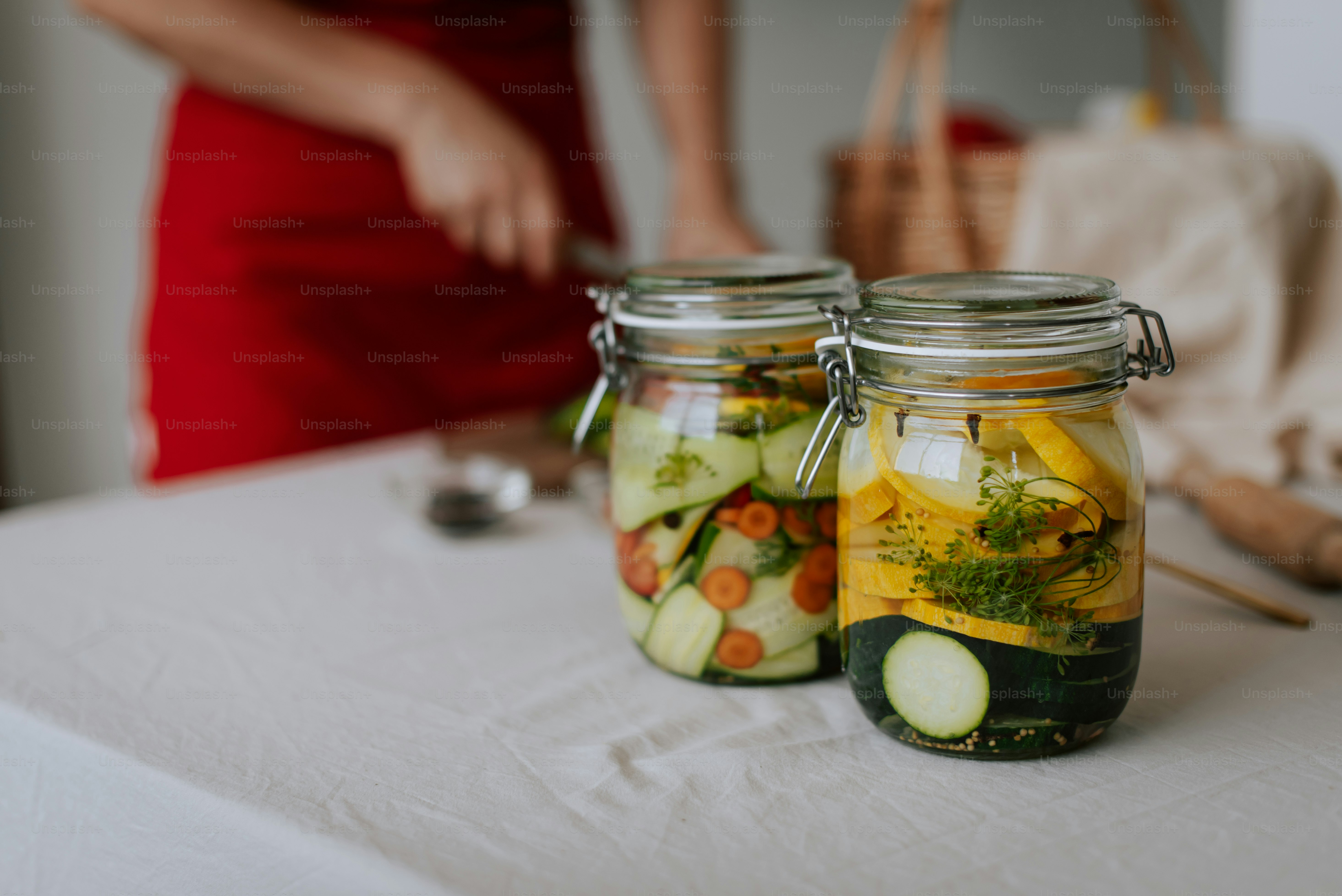 Two mason jars filled with pickles and cucumbers